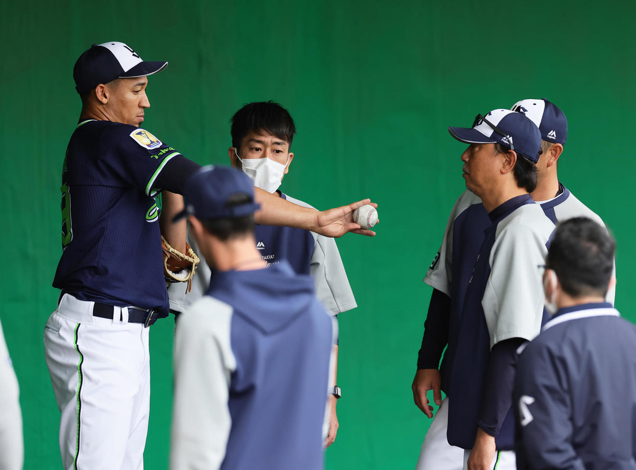 ブルペンで伊藤コーチ（右）から投球指導を受けるヤクルトのエスピナル（撮影・足立雅史）