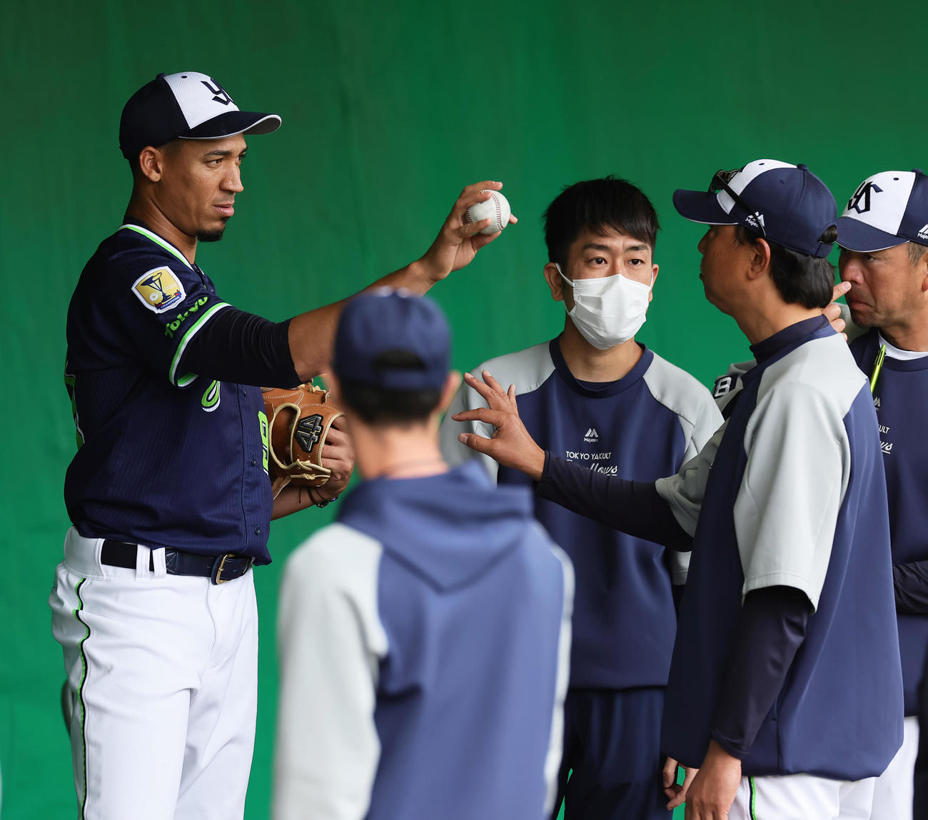 ブルペンでヤクルトのエスピナル（左）は伊藤コーチ（右から2人目）から投球指導を受ける（撮影・足立雅史）