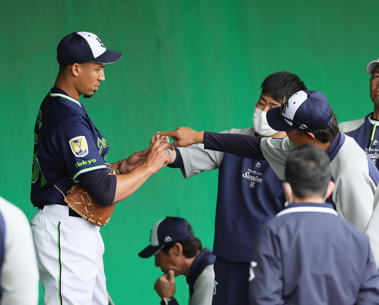 ブルペンでヤクルトのエスピナル（左）は伊藤コーチ（右）から投球指導を受ける。中央下は高津監督（撮影・足立雅史）