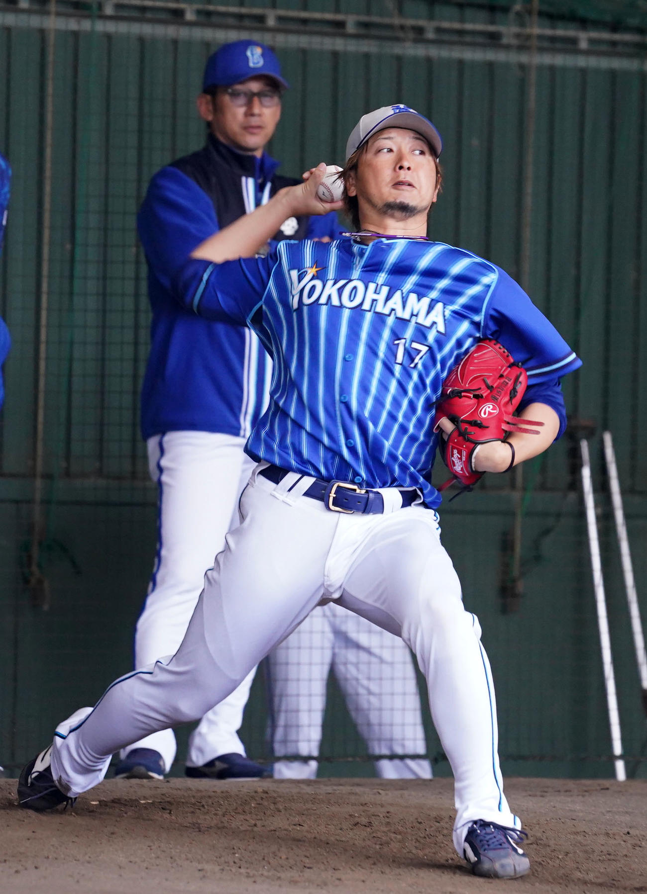 DeNA三浦大輔監督（後方）が見つめる中、ブルペンで投球練習をする三嶋一輝（2023年2月10日撮影）