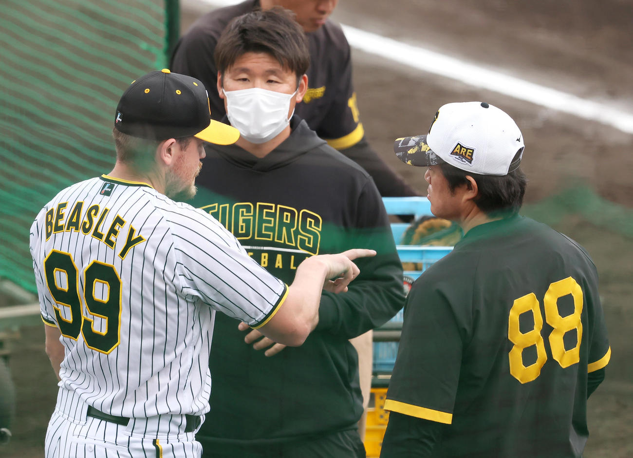 実戦形式の打撃練習で投球を終えたビーズリー（左）は安藤投手コーチ（右）と話す（撮影・上山淳一）