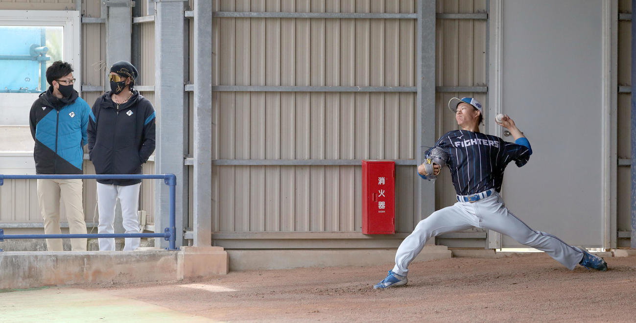 中日対日本ハム　日本ハム新庄監督（左）はブルペンで投球する矢沢を視察する（撮影・佐藤翔太）