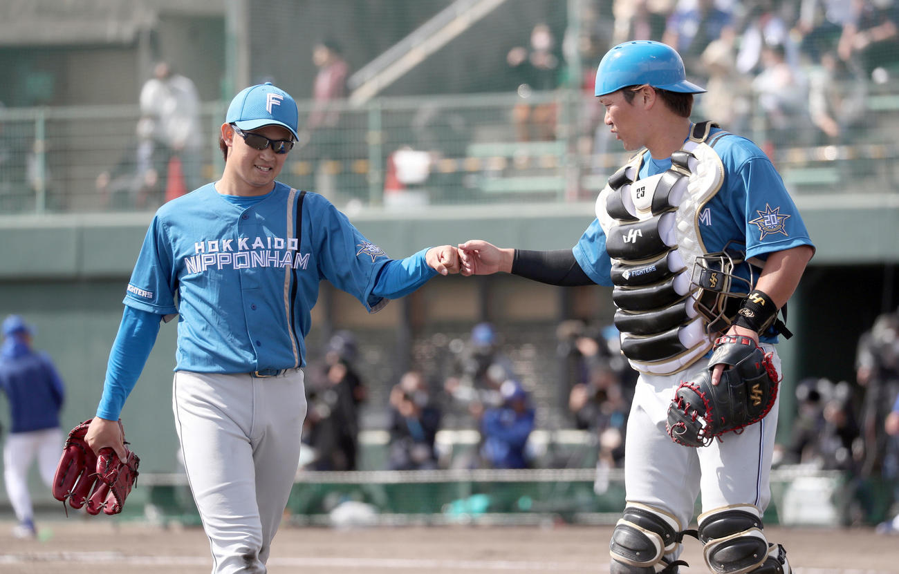 中日対日本ハム　2回裏を抑えた鈴木（左）は伏見とグータッチを交わす（撮影・佐藤翔太）