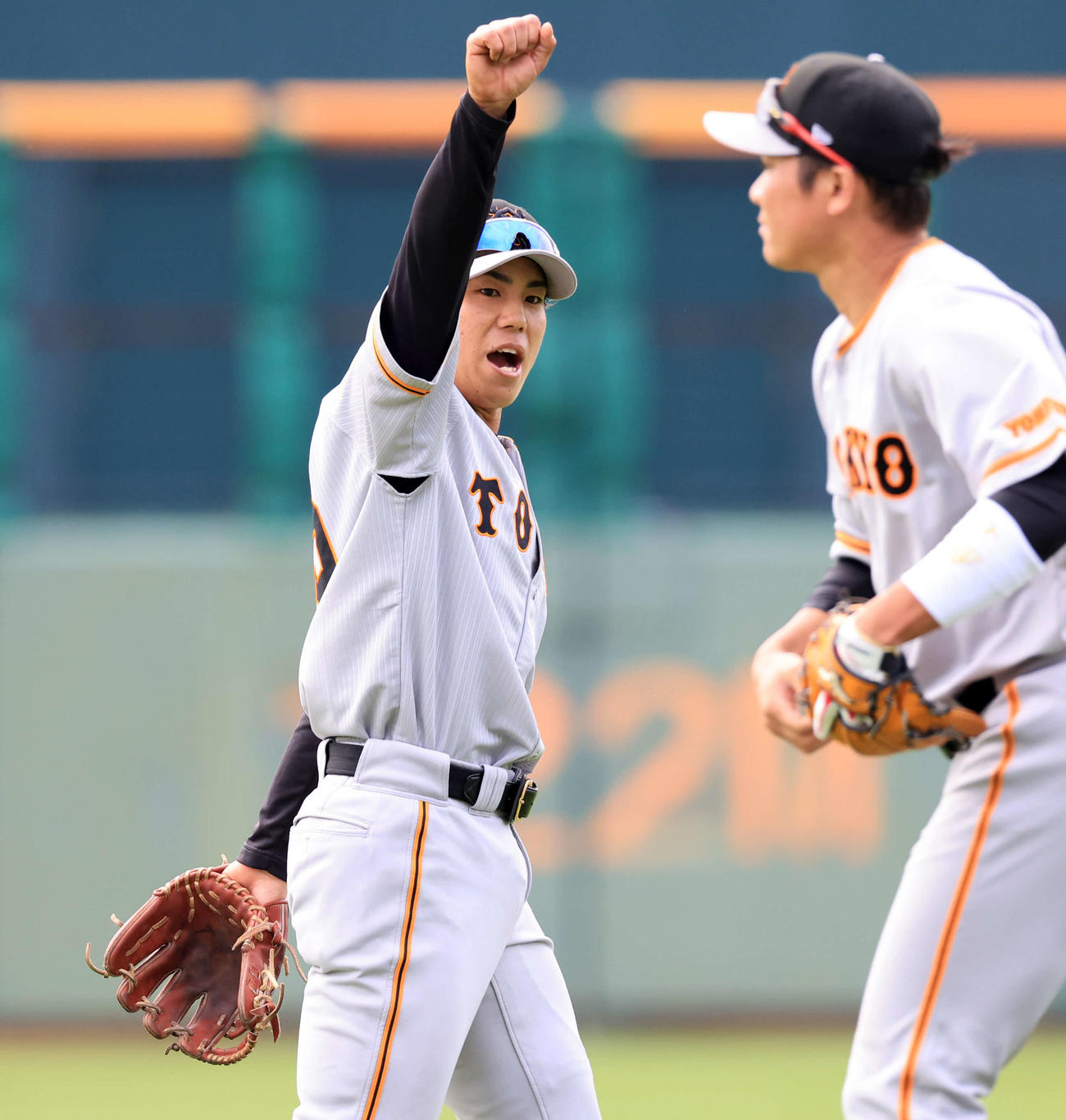 中継プレーで本塁に好送球し、ガッツポーズする巨人門脇（左）。手前は坂本（撮影・浅見桂子）