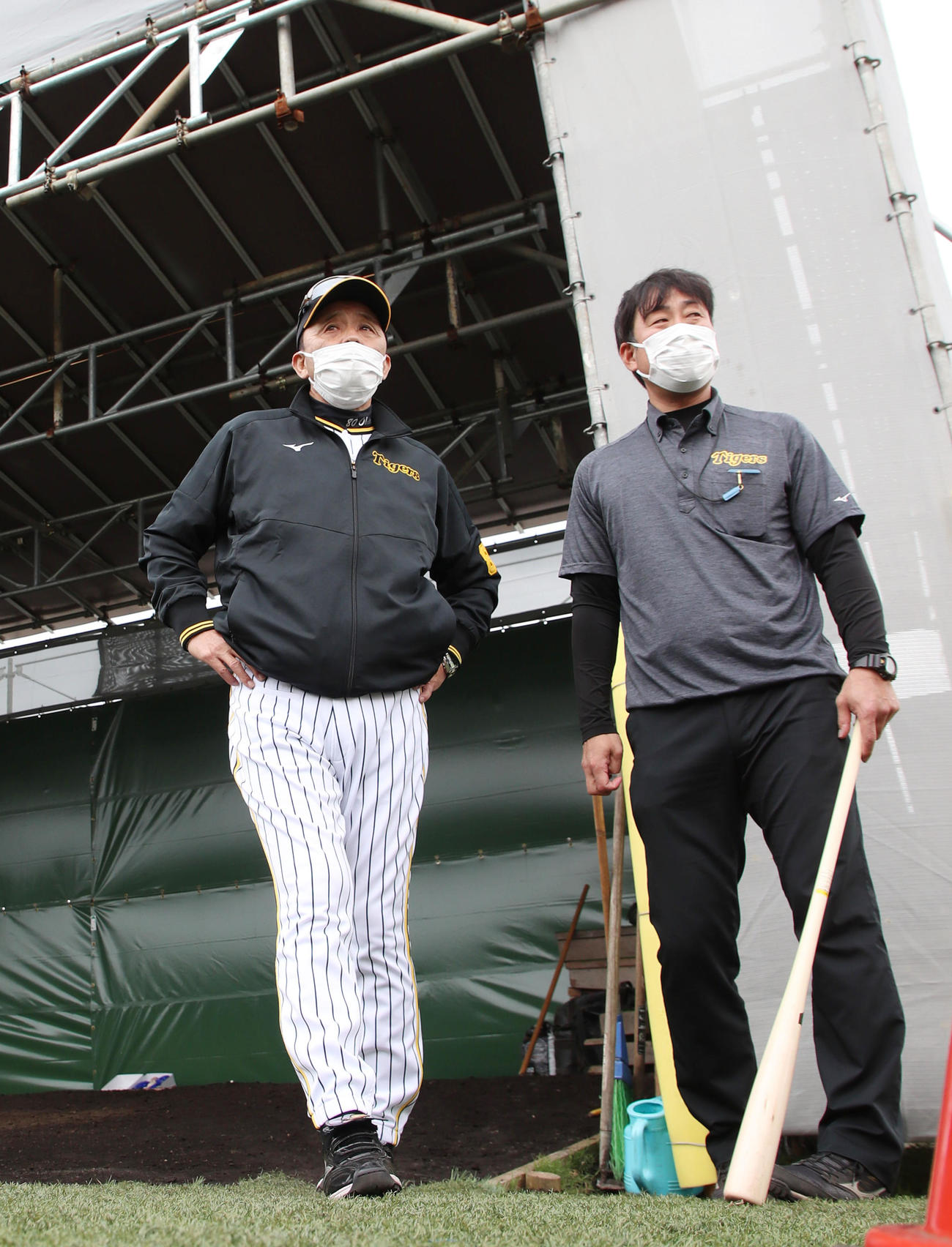 具志川野球場のブルペンを見る岡田監督(左）と藤原広報（撮影・加藤哉）