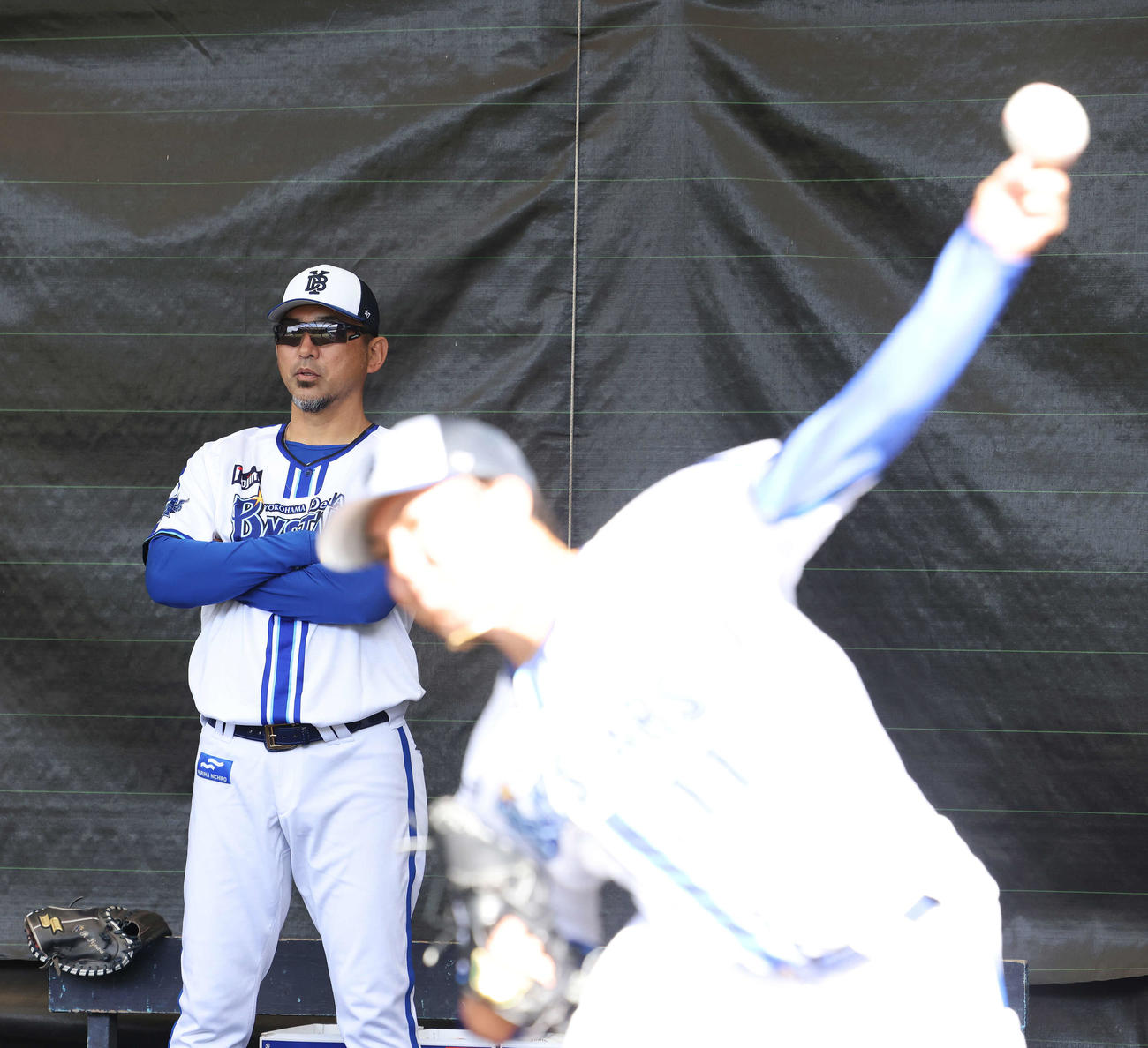 ブルペン投球する投手陣を見るDeNA斎藤チーフ投手コーチ（撮影・河田真司）
