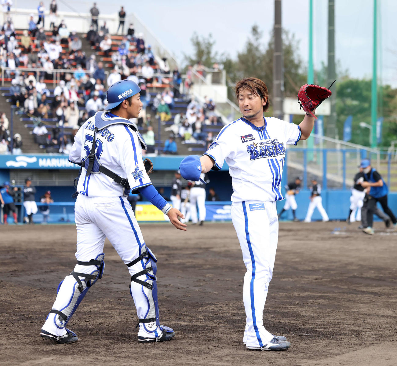 DeNA対ロッテ　7回表を抑え、山本（左）に迎えられる三嶋（撮影・河田真司）
