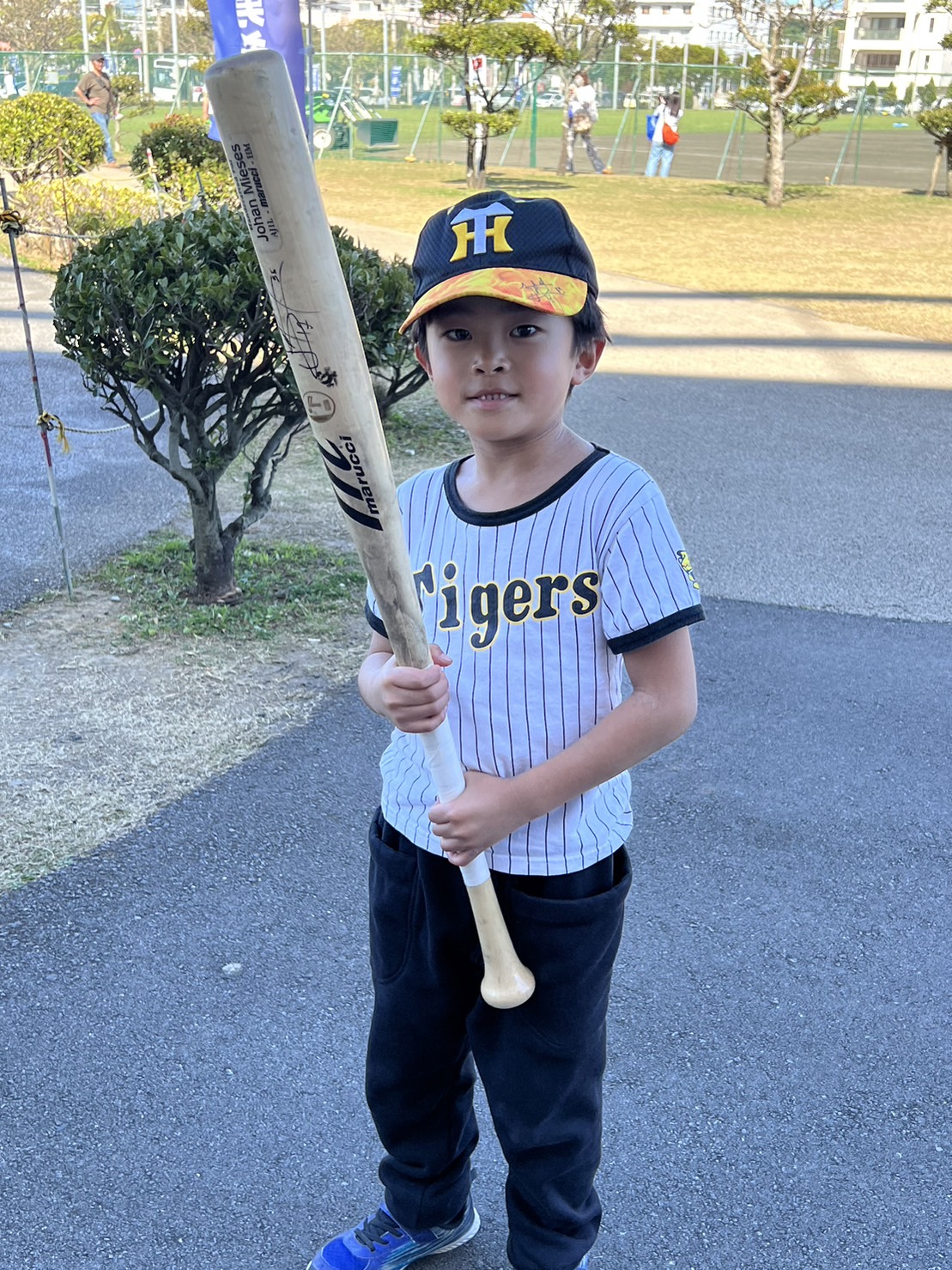 阪神ミエセスからバットをもらった井川結心（いかわ・ゆいと）君（6歳）はバットを手に笑顔＝2023年2月23日、アグレスタジアム北谷