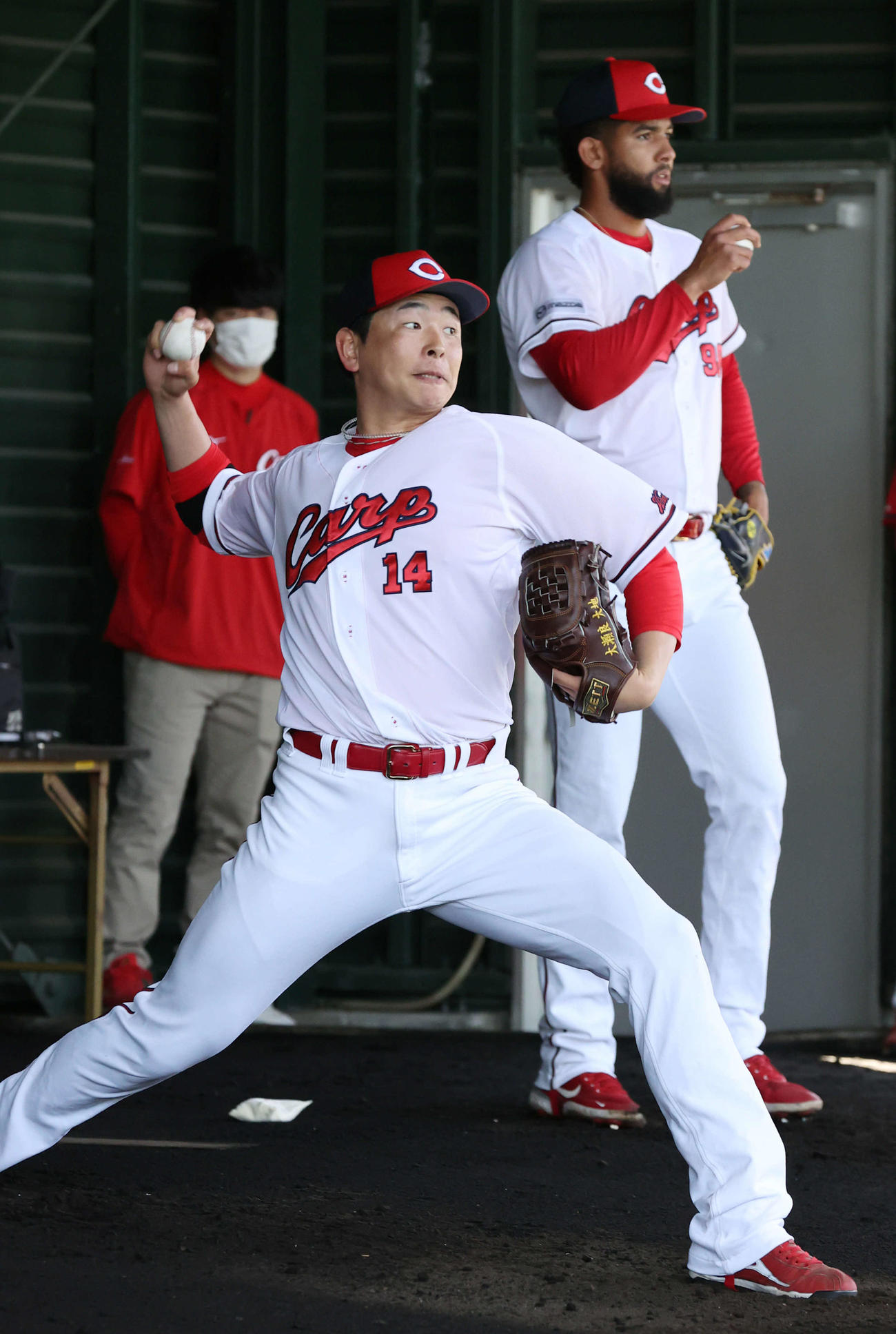 広島沖縄キャンプ　ブルペンで投げる大瀬良。右はコルニエル（撮影・加藤孝規）