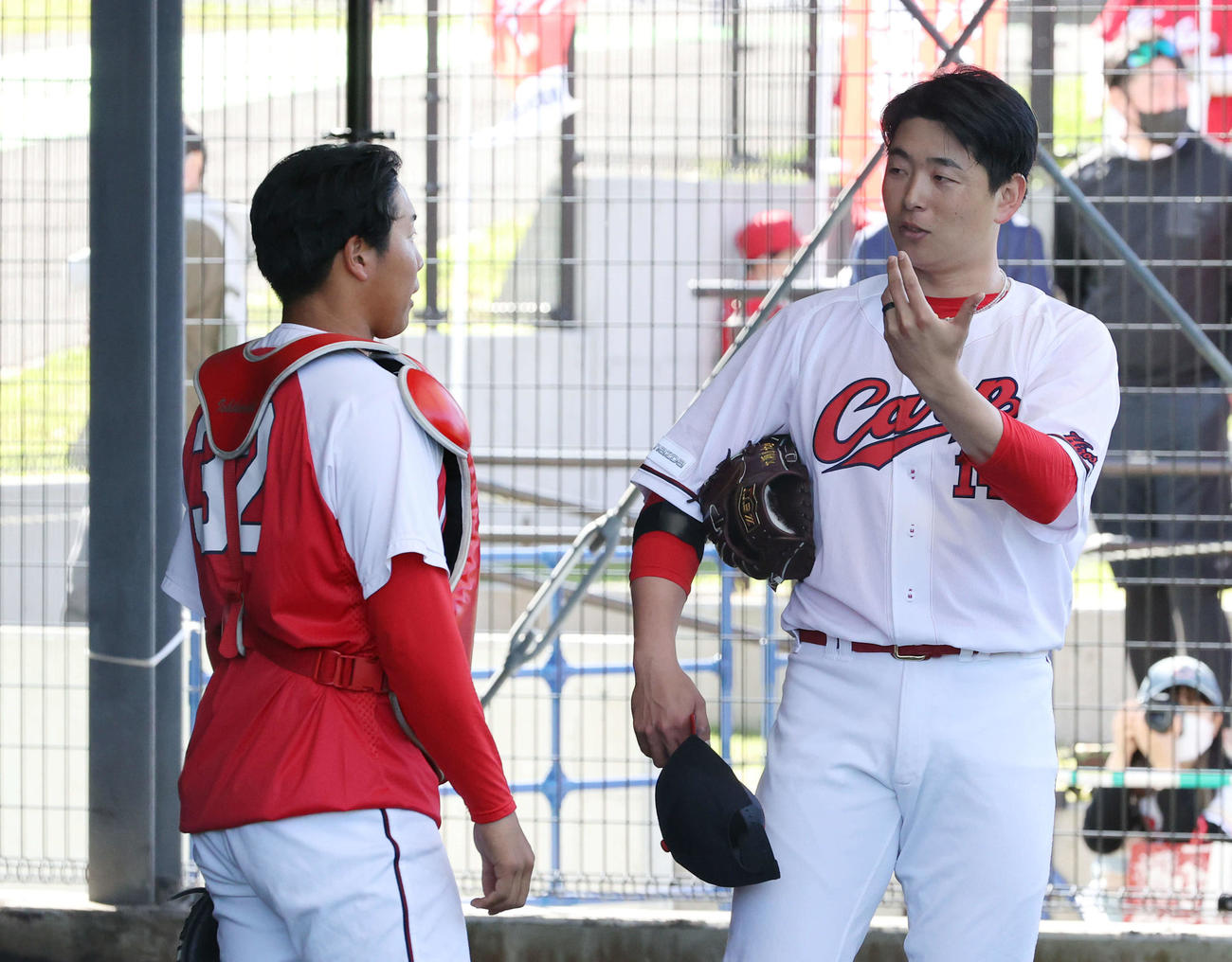 広島沖縄キャンプ　ブルペンで投球後、石原（左）と話し合う大瀬良（撮影・加藤孝規）