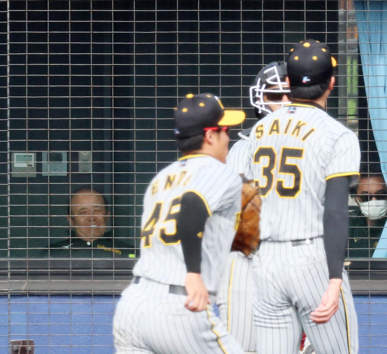日本ハム対阪神　6回裏、ネット裏から白い歯を見せて才木を見る岡田監督（撮影・加藤哉）