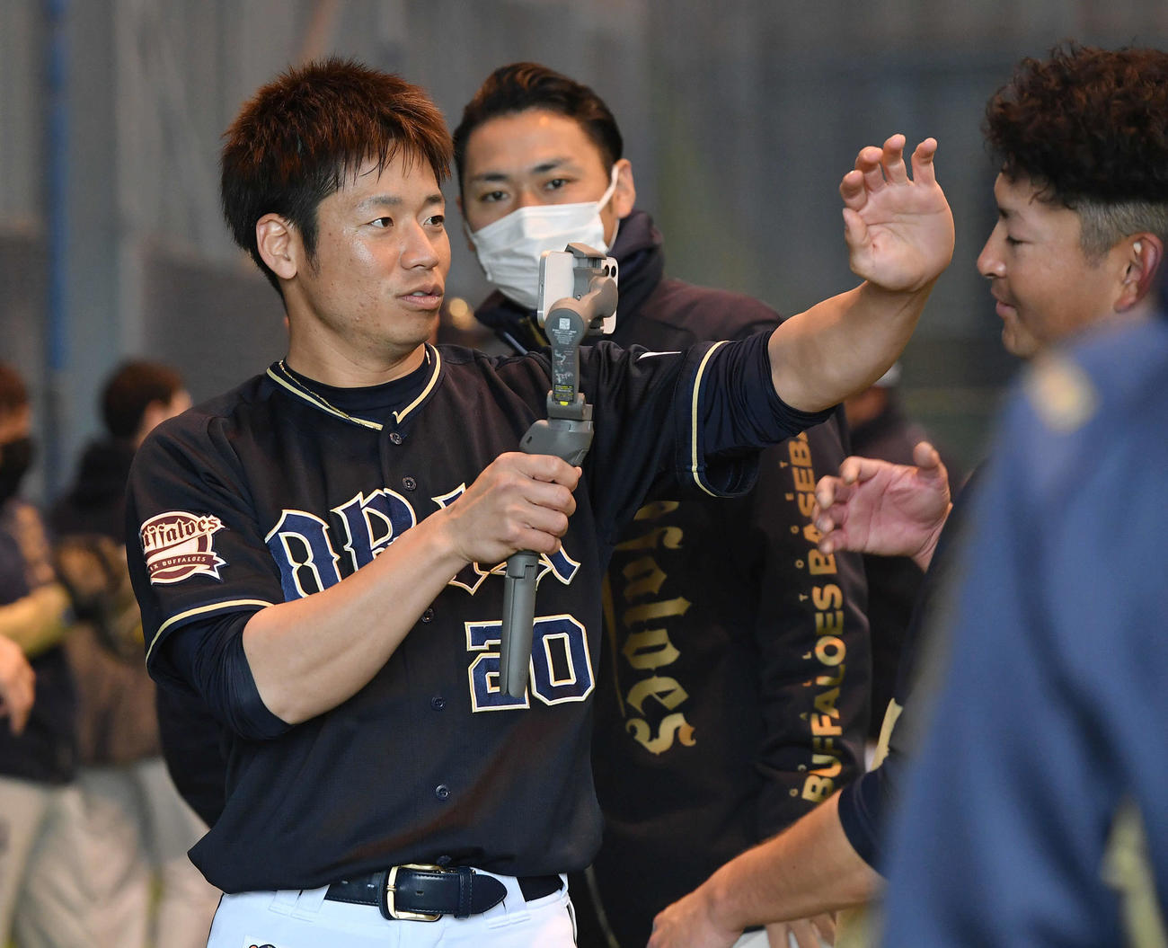 球団のライブ配信スマートフォンを借りて小木田（右）を撮影する近藤（撮影・岩下翔太）