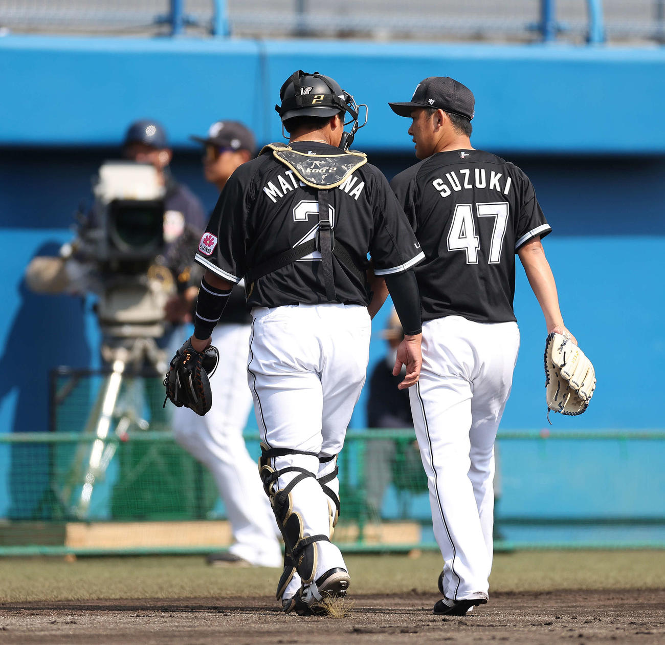 西武対ロッテ　1回裏を抑え、言葉を交わしながらベンチに戻る松川（左）と鈴木（撮影・河田真司）