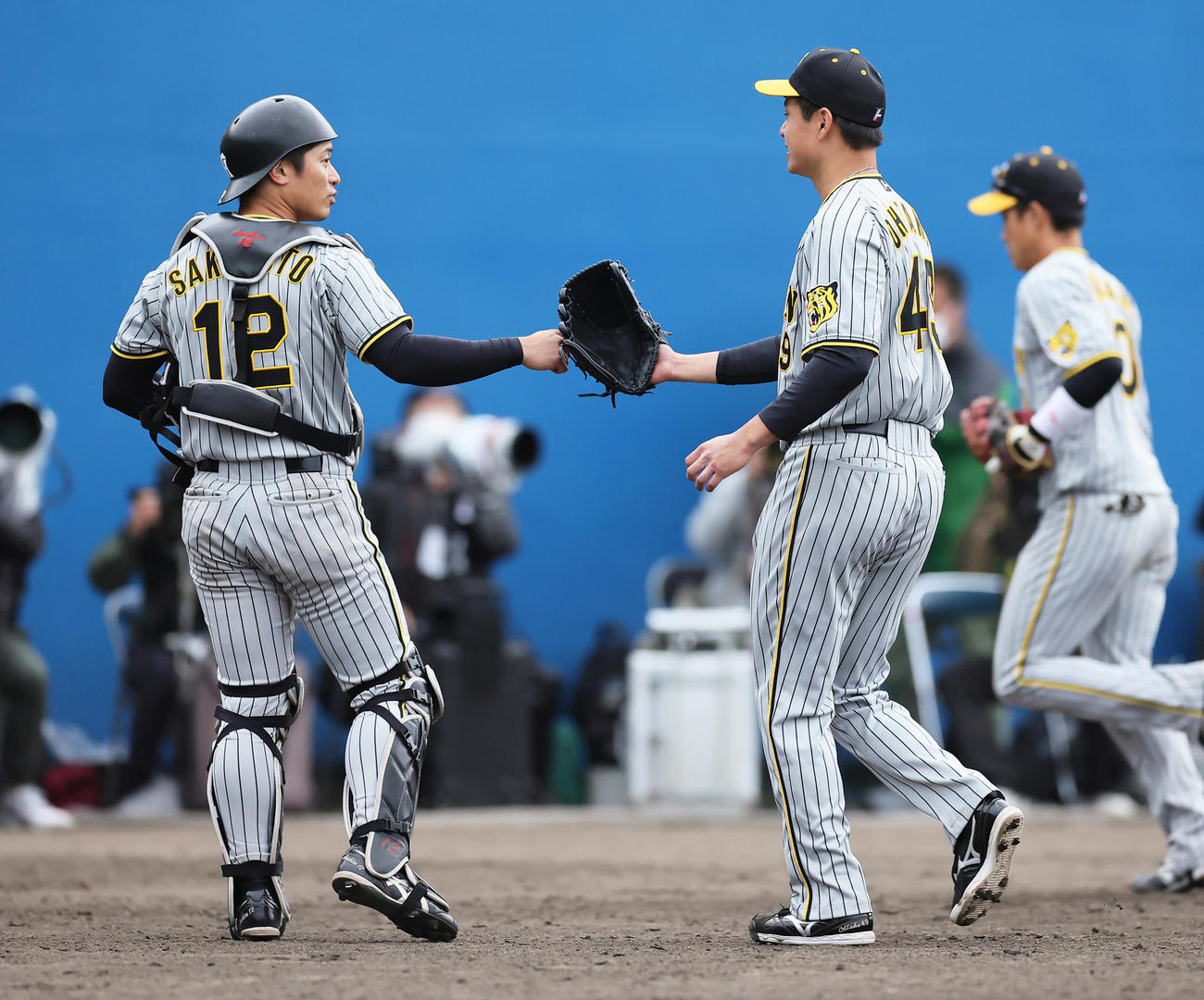 ヤクルト対阪神　8回裏ヤクルト2死一塁、一塁走者古賀の二塁盗塁を阻止した捕手坂本（左）とタッチを交わす大竹（撮影・足立雅史）