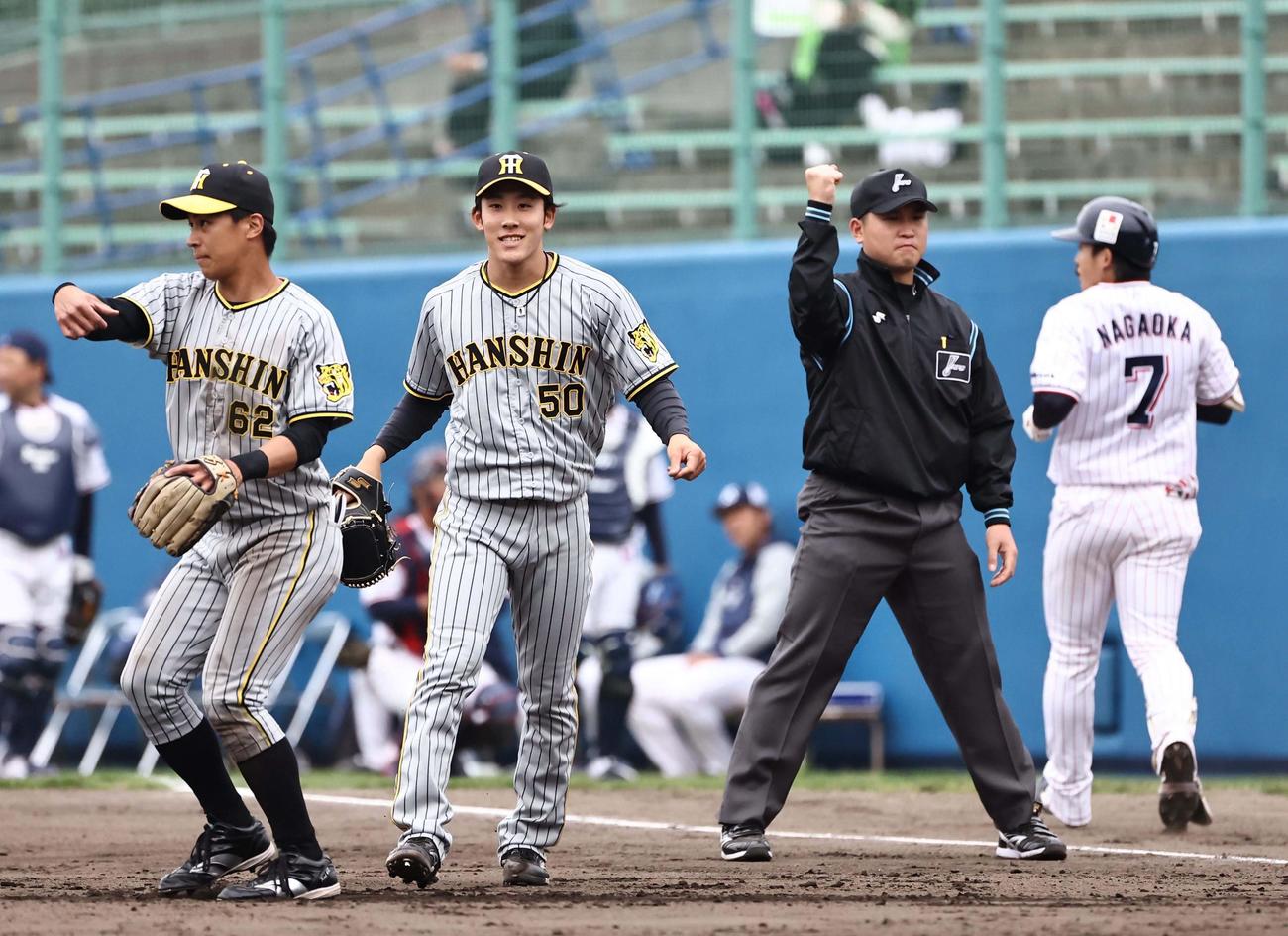 ヤクルト対阪神オープン戦　5回裏ヤクルト無死、富田（左から2人目）は長岡（右）を一ゴロに打ち取り笑顔を見せる（撮影・上田博志）