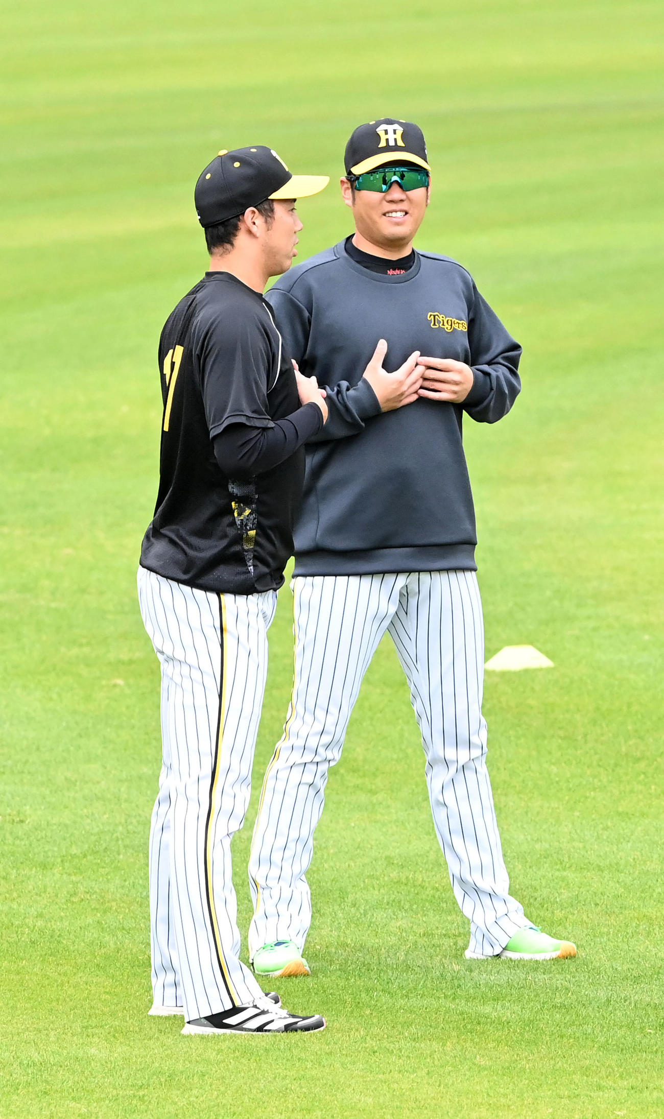 笑顔でアップを行う西勇（右）。左は青柳（撮影・前岡正明）
