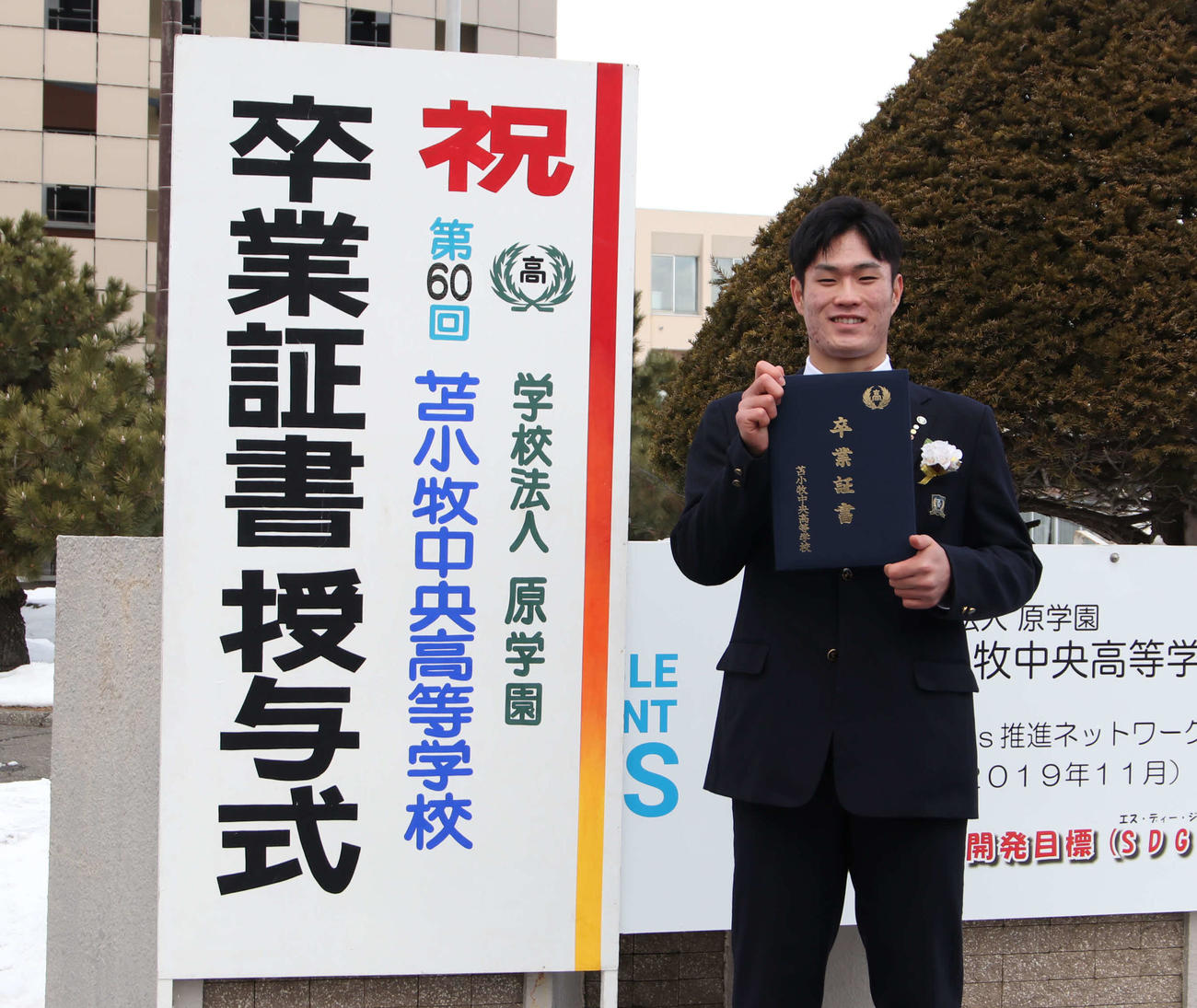 苫小牧中央高の卒業式に出席し、記念撮影に応じる広島のドラフト1位斉藤（撮影・山崎純一）