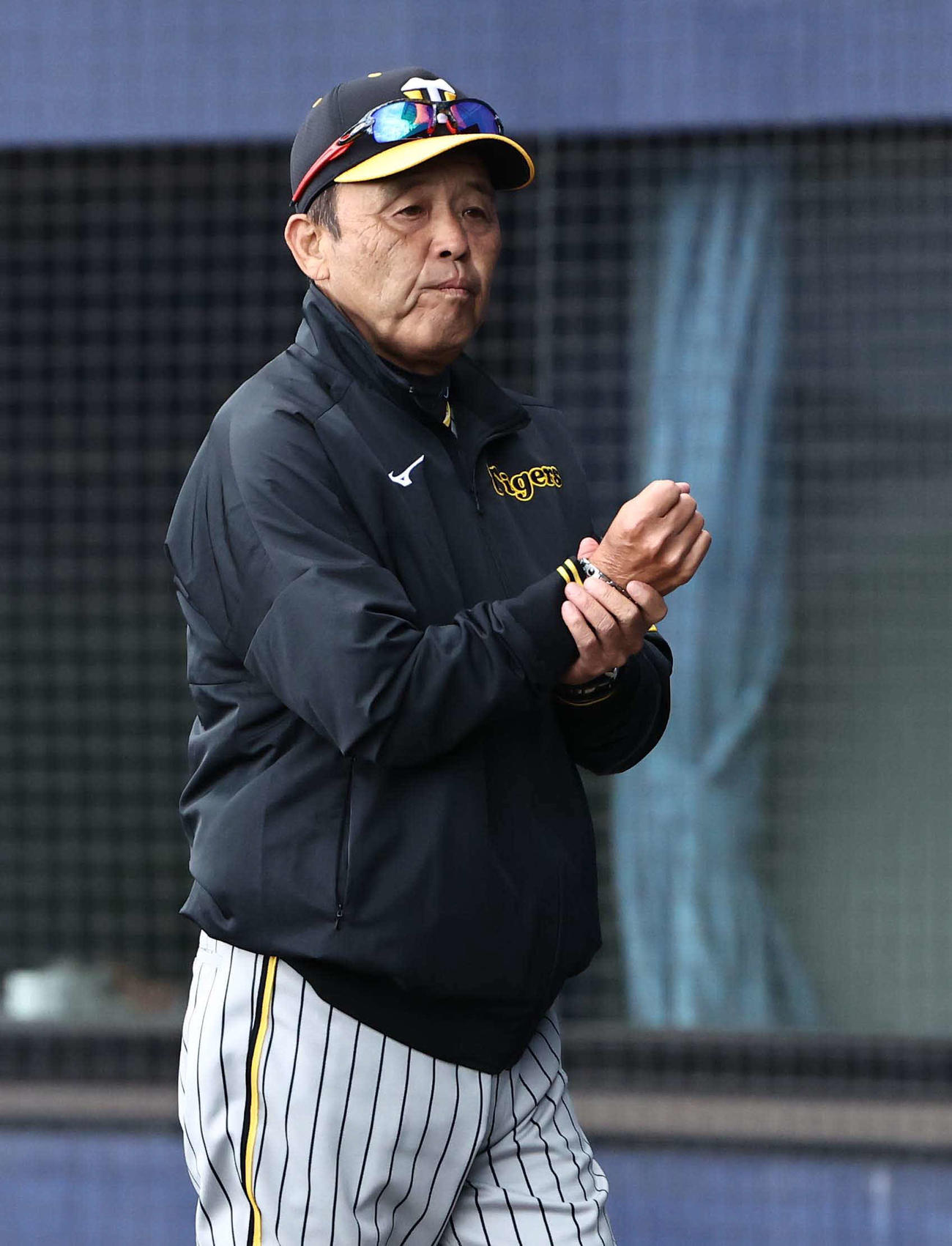 日本ハム対阪神　選手交代を告げた岡田監督は拳を押さえるようにしてベンチに引き揚げる（撮影・上田博志）
