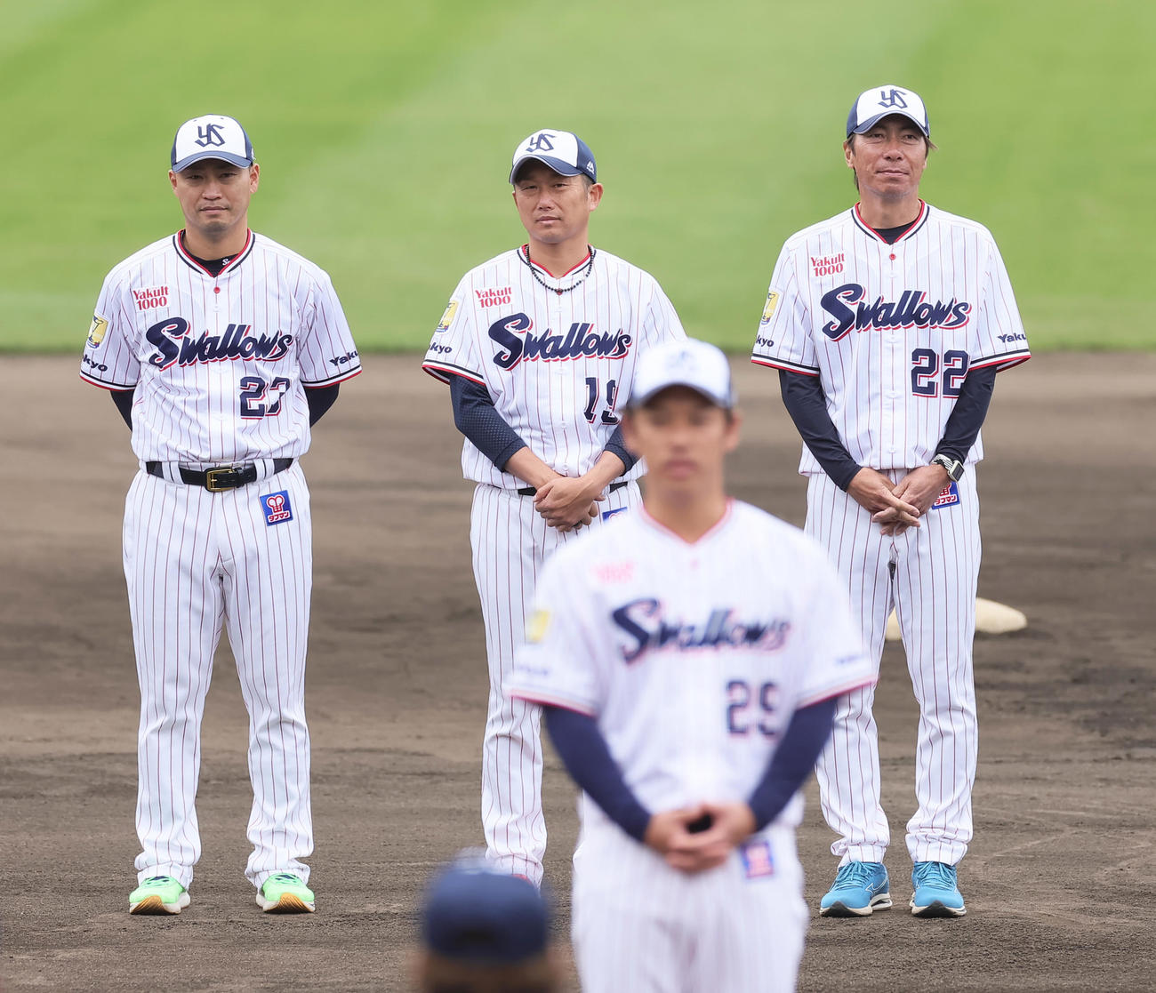 キャンプを打ち上げ、小川（手前）のあいさつを聞くヤクルトの、左から青木、石川、高津監督（撮影・足立雅史）