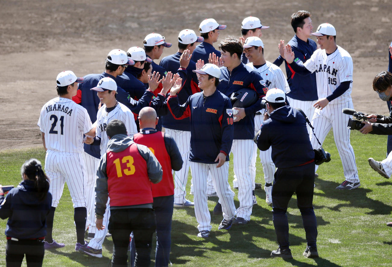 侍ジャパンの宮崎合宿を打ち上げ、タッチを交わす山本（中央）と村上（同右）ら（撮影・前田充）