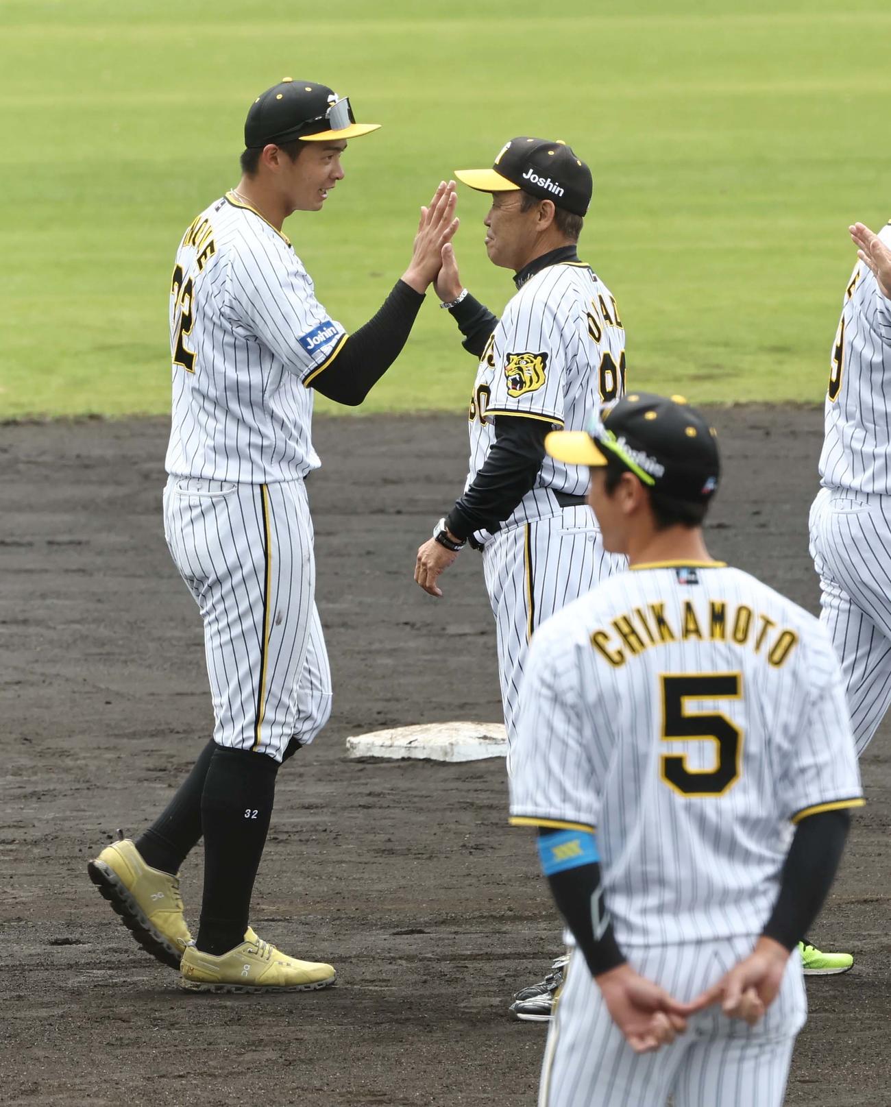 春季キャンプでMVPに選ばれた井上（左）は岡田監督とハイタッチする（撮影・上田博志）