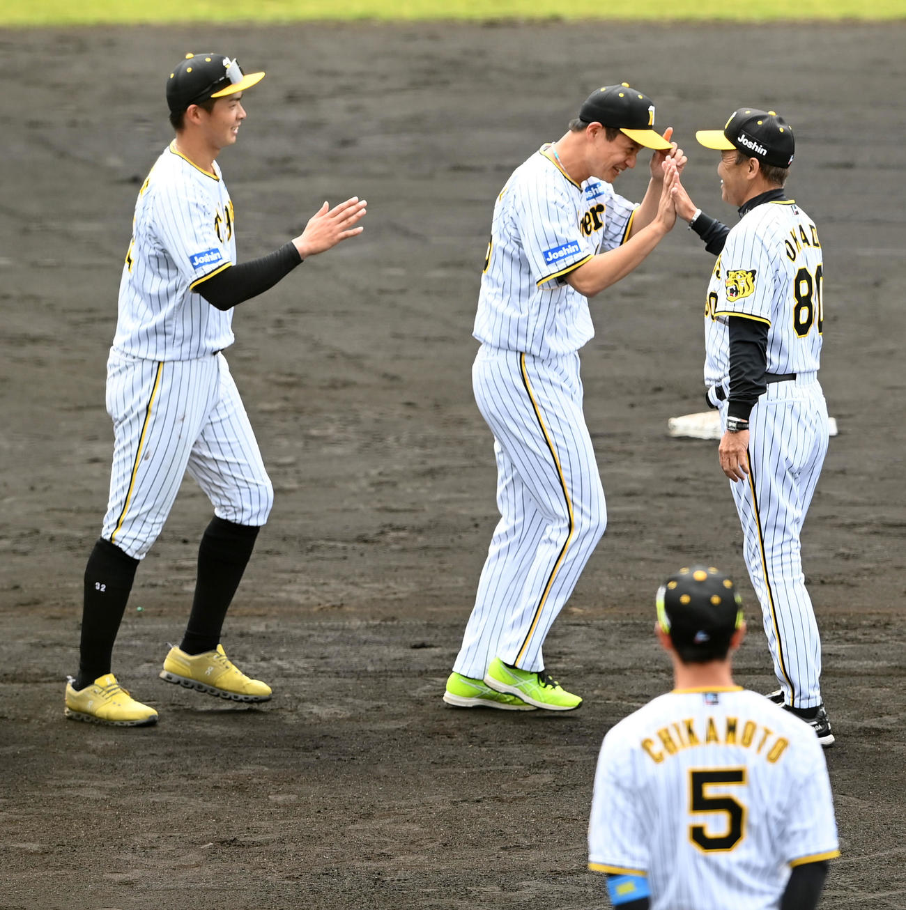 井上、大竹（左から）とタッチする岡田監督（撮影・前岡正明）