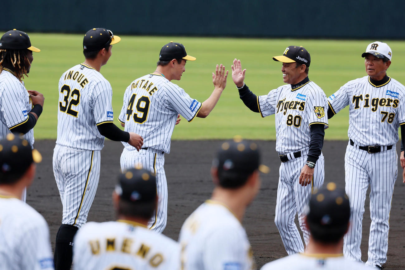 手締めを終え大竹らナインとタッチする岡田監督。左は井上、右は平田ヘッドコーチ（撮影・加藤哉）