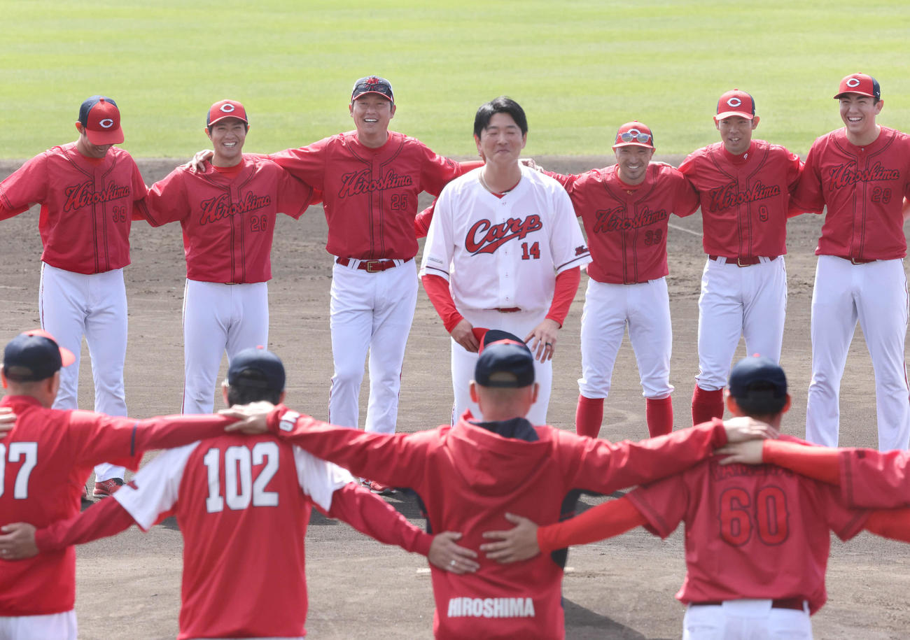 広島沖縄キャンプ　肩を組み、キャンプの打ち上げをする広島ナイン。輪の中であいさつする大瀬良選手会長は1人だけホームユニホーム姿。後列左から長谷部、益田、新井監督、藤井ヘッドコーチ、菊池、秋山ら（撮影・加藤孝規）