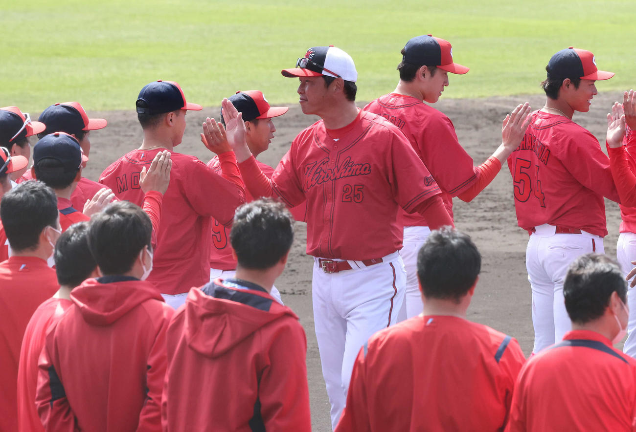 広島沖縄キャンプ　ナインらとタッチする新井監督（中央）（撮影・加藤孝規）