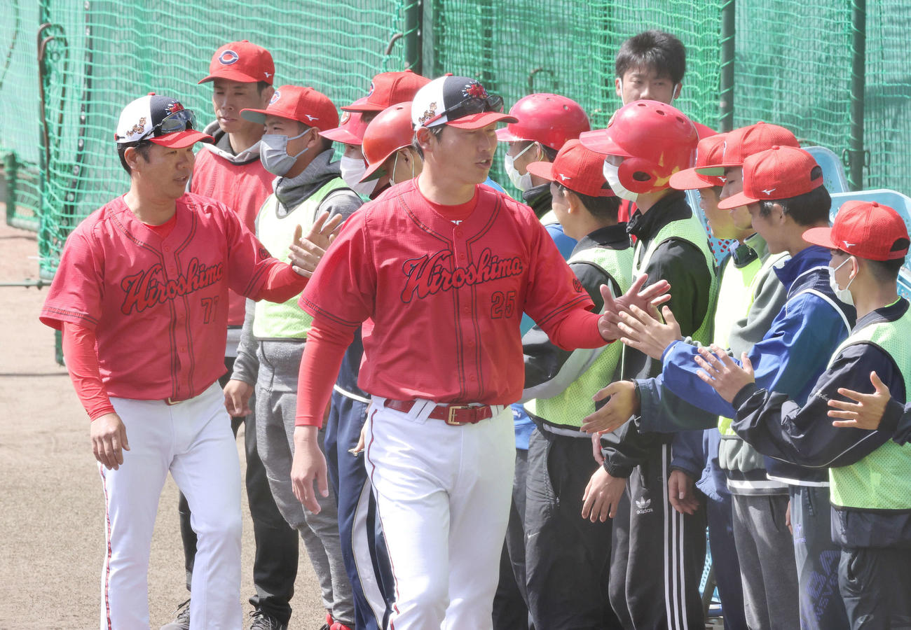 広島沖縄キャンプ　地元のキャンプスタッフとタッチをする新井監督（中央）。左は藤井ヘッドコーチ（撮影・加藤孝規）