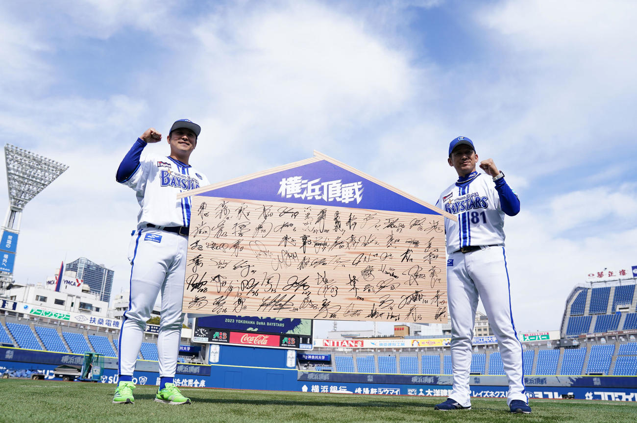 巨大絵馬を手に笑顔でガッツポーズするDeNA佐野（左）と三浦監督（撮影・横山健太）