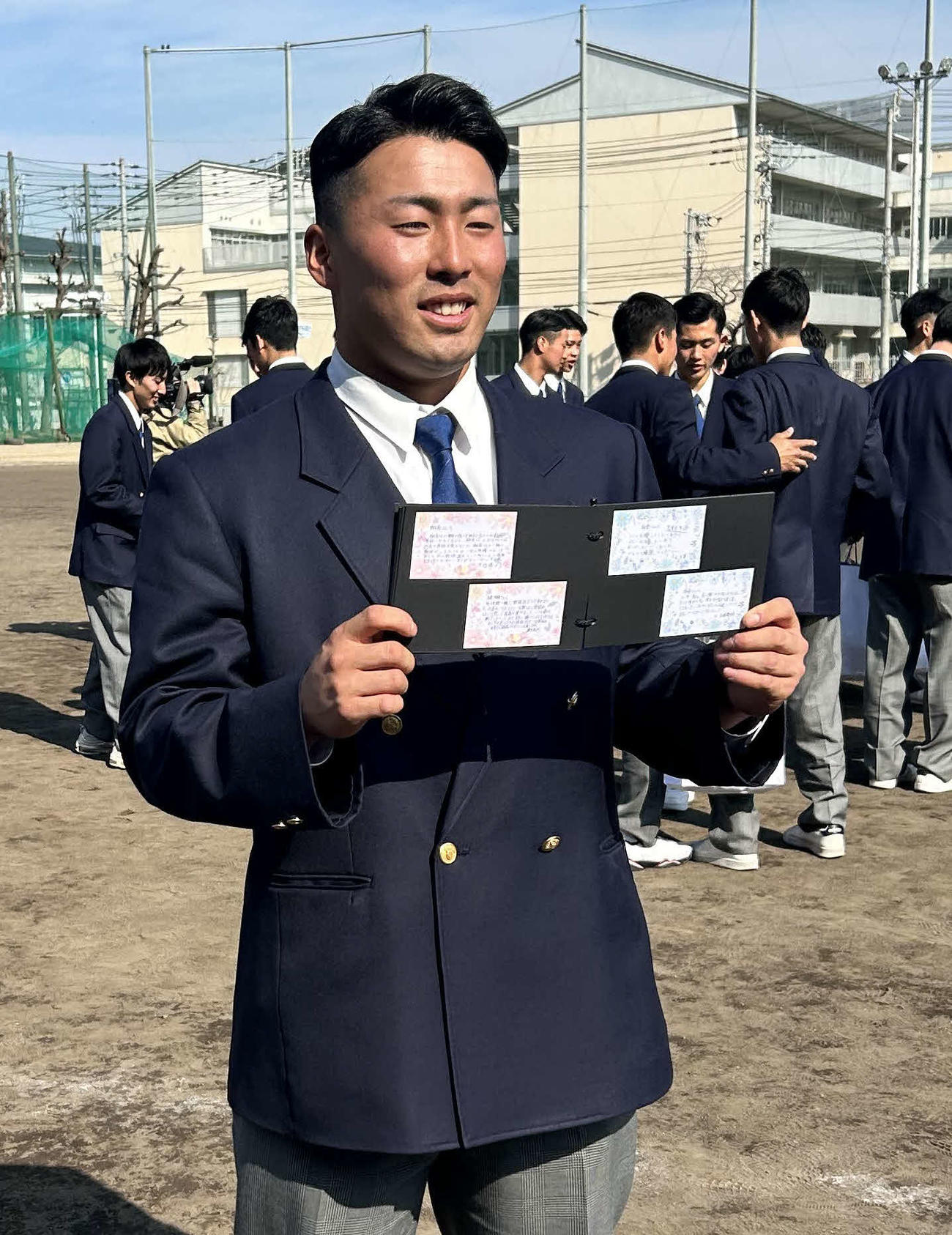 後輩からプレゼントされたアルバムを手にする巨人浅野（撮影・上田悠太）