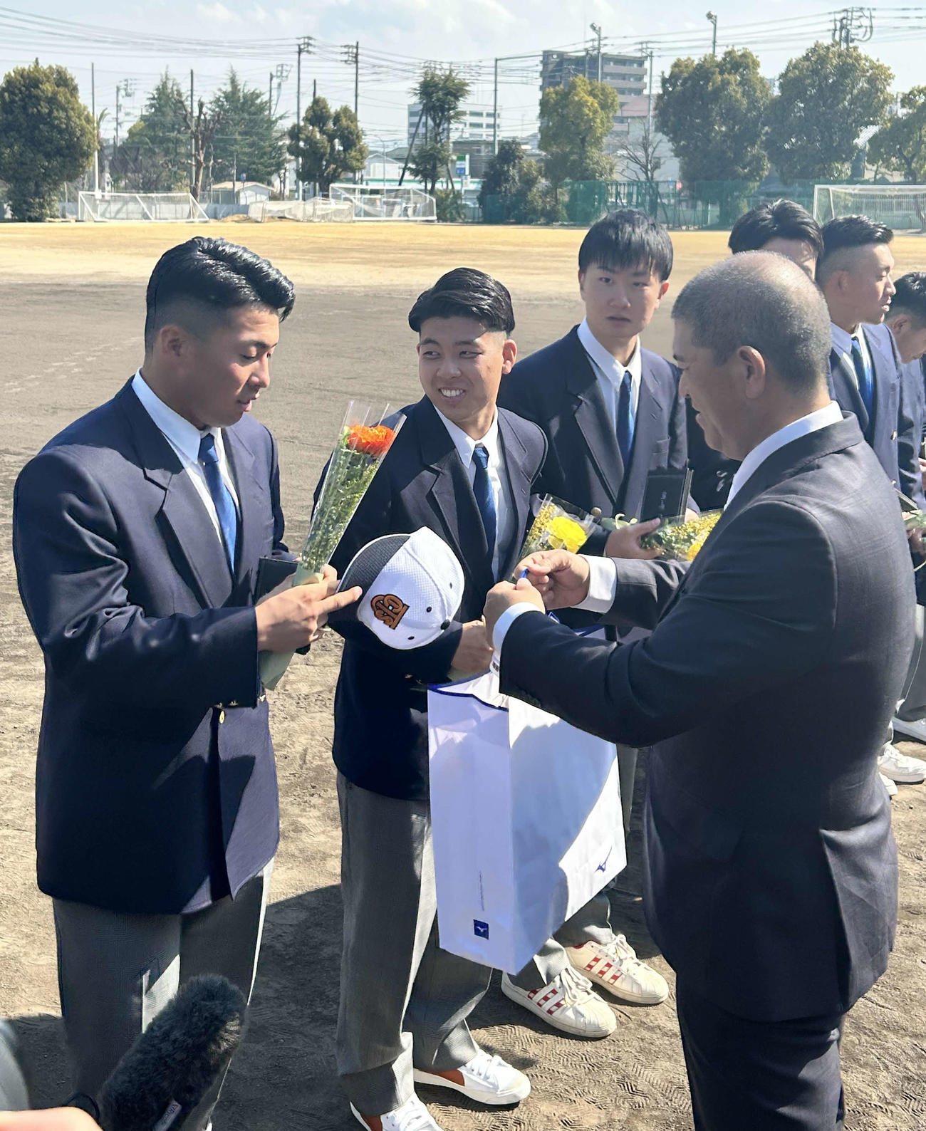 高松商・長尾監督（右手前）から卒業記念品を受け取る巨人浅野（左）（撮影・上田悠太）