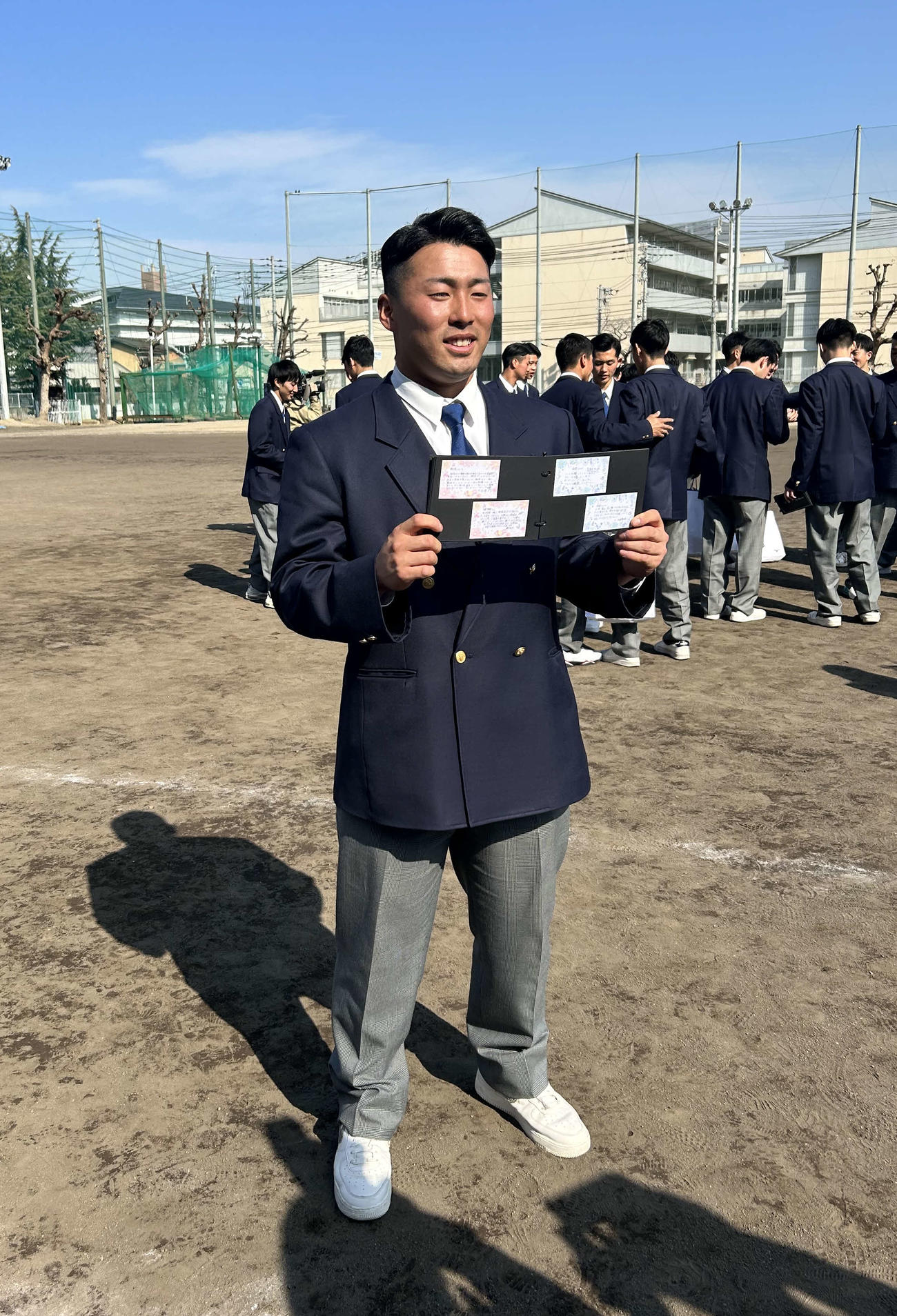 後輩からプレゼントされたアルバムを手にする巨人浅野（撮影・上田悠太）