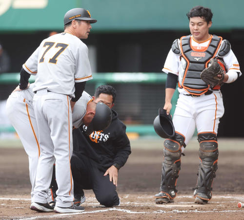 巨人紅白戦　6回表、堀岡の投球が手に当たり、うずくまる中島（左から2人目）（撮影・宮地輝）