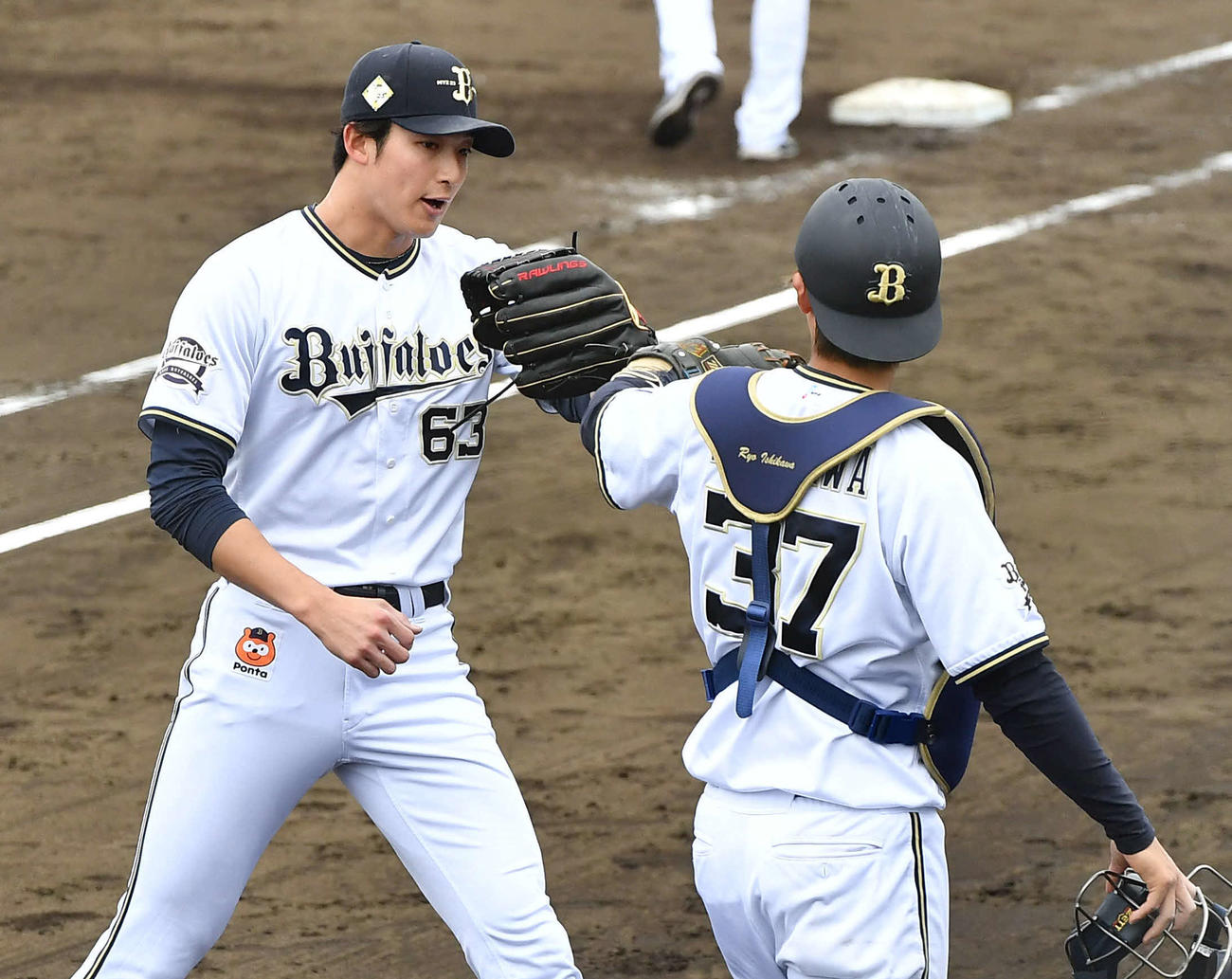 2月23日、練習試合DeNA2軍戦で5回表を無失点に抑えた山崎颯は、石川（右）とタッチを交わす