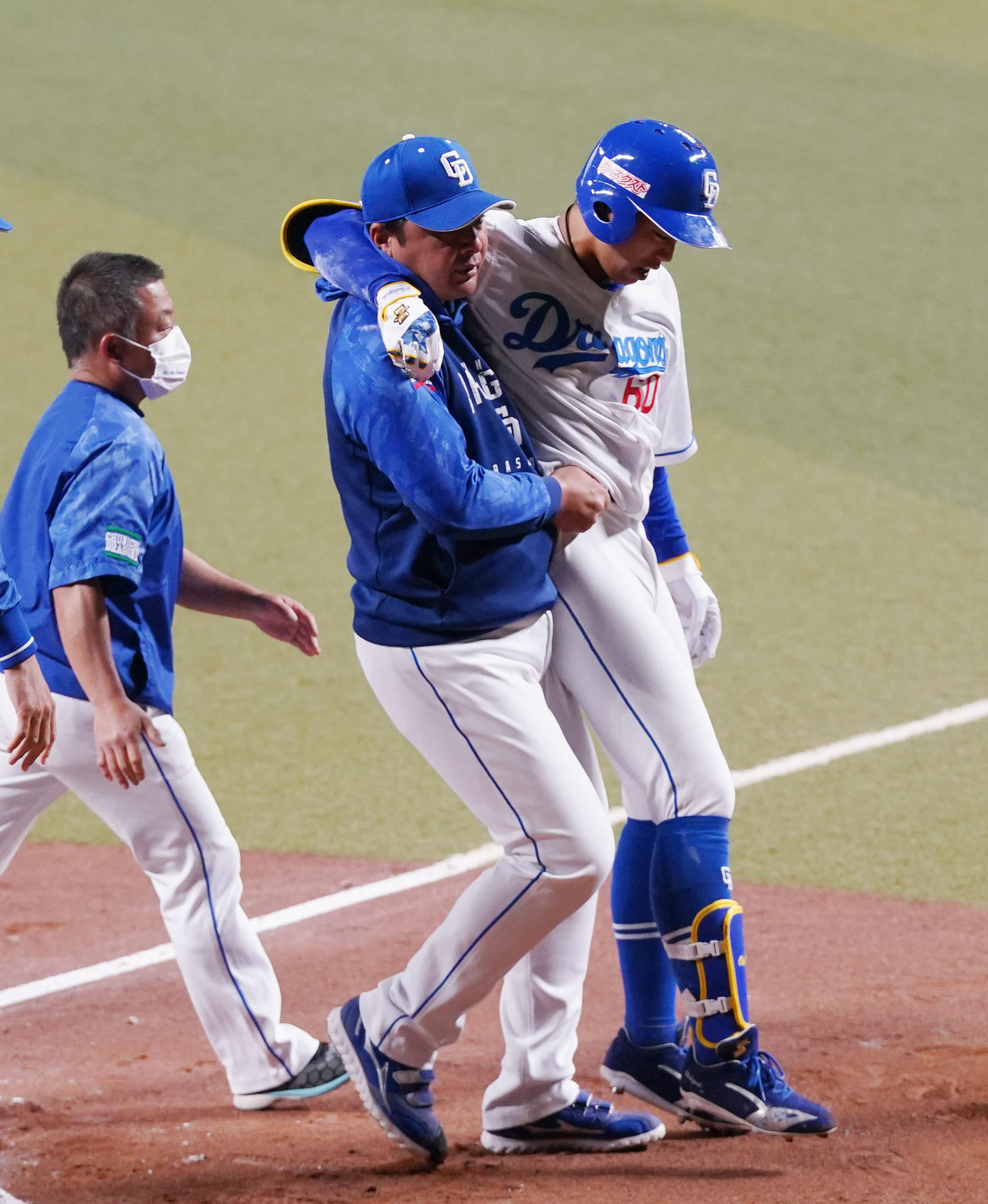 中日との合同練習でダルビッシュから右膝付近に死球を受け、森野コーチ（中央）に担がれ、負傷退場する岡林（右）（撮影・狩俣裕三）