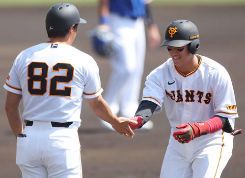 巨人対サムスン　1回裏巨人2死一塁、右前打を放ち、鈴木外野守備兼走塁コーチ（左）とタッチする増田陸（撮影・宮地輝）