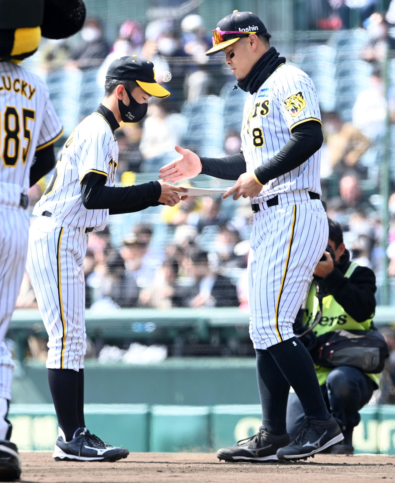 阪神対オリックス　NPB12球団ジュニアトーナメントで優勝した阪神タイガースジュニアチームのの小松主将（左）を記念品を贈呈するOBの佐藤輝（撮影・前岡正明）