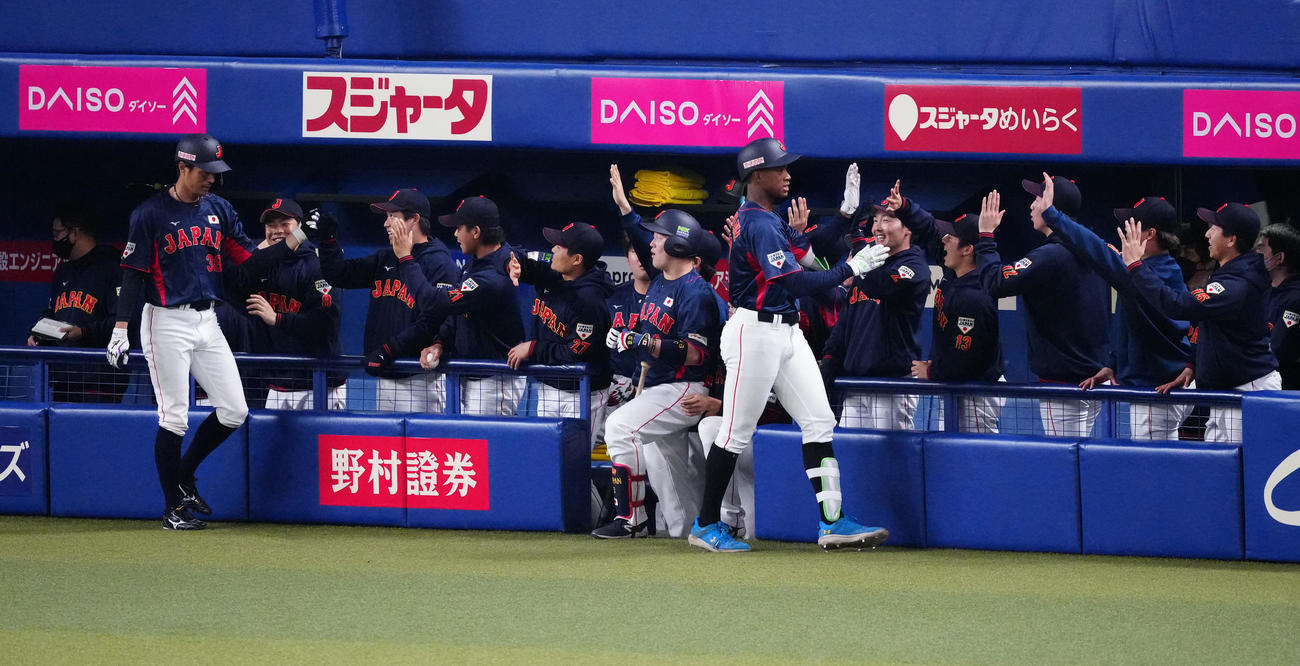中日対侍ジャパン　8回表侍ジャパン無死一塁、2点本塁打を放ち、チームメートとタッチを交わす万波（手前右）（撮影・江口和貴）