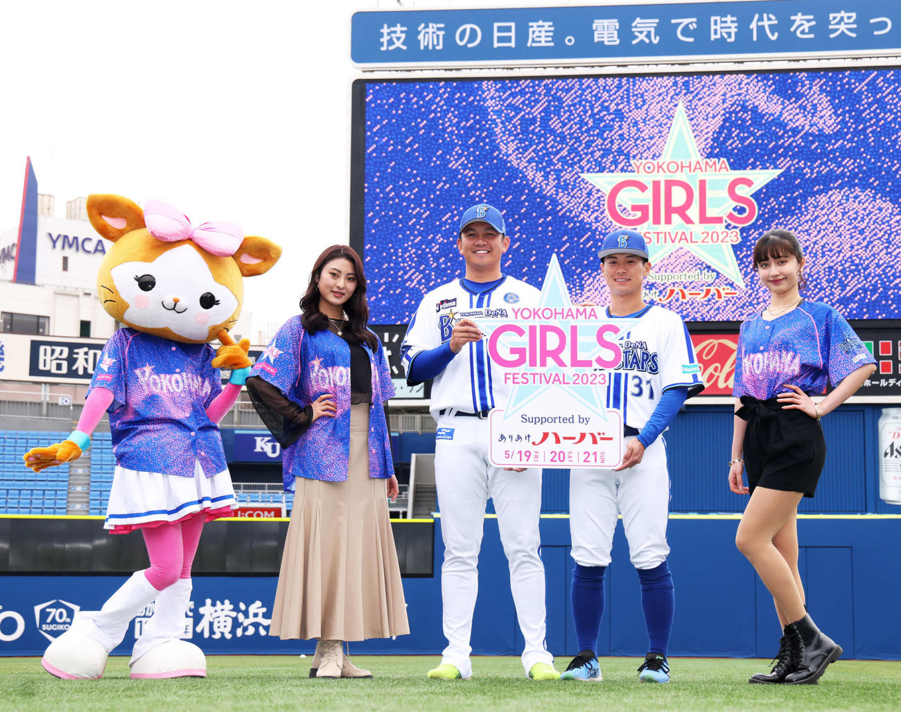 「YOKOHAMA GIRLS　☆　FESTIVAL 2023」のスペシャルユニホームを着用したDB．キララ（左）、dianaのYui（左から2人目）Reina（右）と写真に納まるDeNA山崎（中央）と柴田（撮影・河田真司）