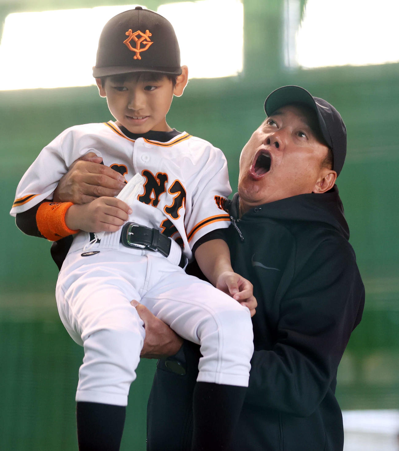 練習を見学していた巨人ファンの男の子を持ち上げる原監督（撮影・宮地輝）