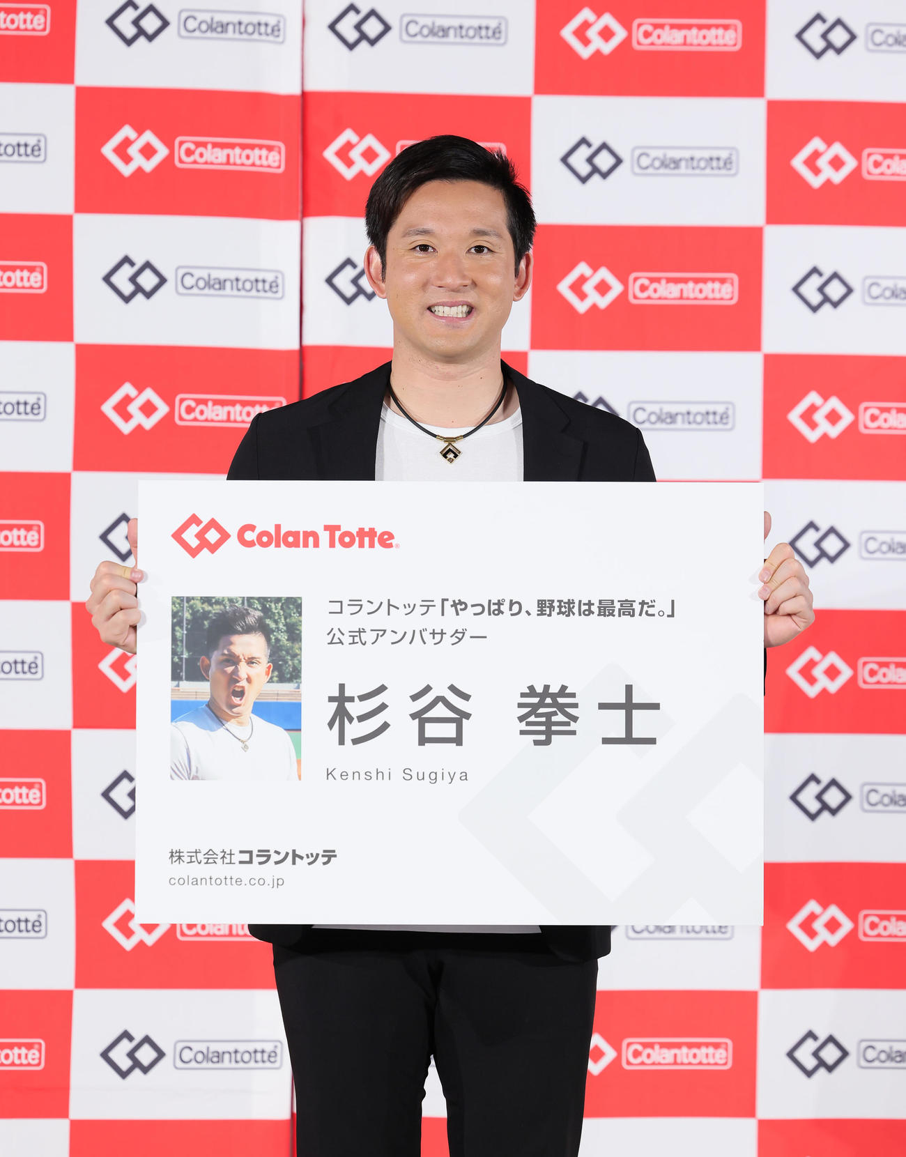 就任式で巨大名刺を手に笑顔を見せる杉谷氏（撮影・足立雅史）