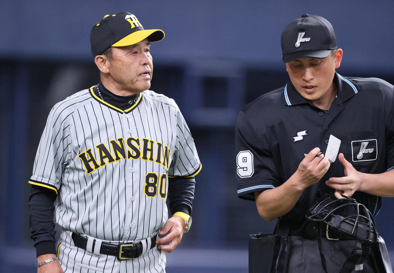 5回終了後、岡田監督（左）は球審に選手交代を告げる（撮影・上山淳一）
