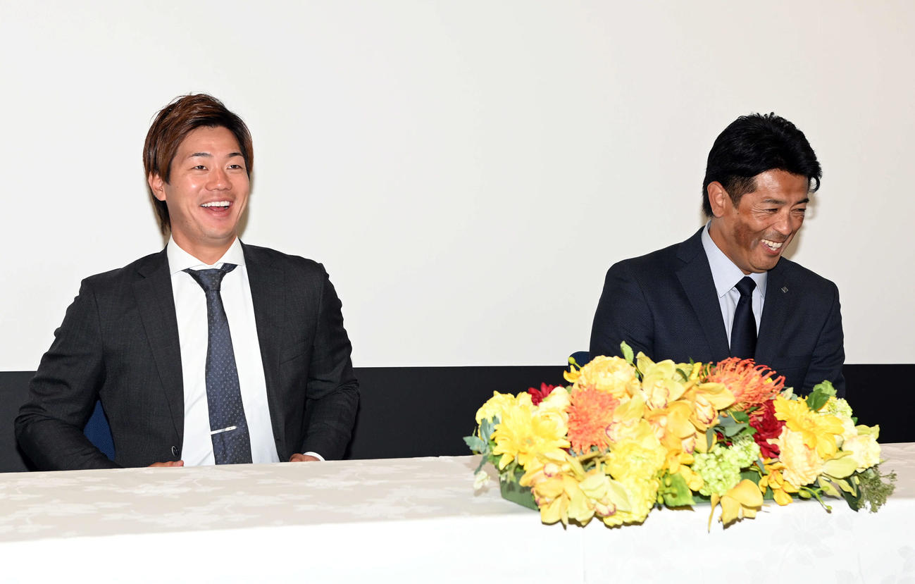 ロッテから移籍し会見で笑顔を見せる日本ハム福田光。右は稲葉GM（撮影・たえ見朱実）