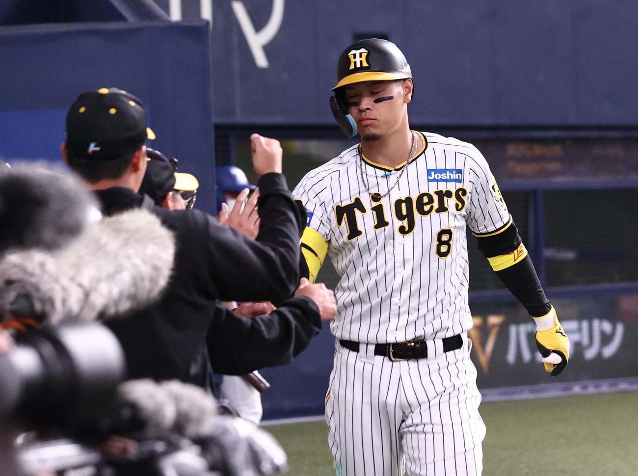 阪神対韓国　8回裏阪神無死、中越え本塁打を放った佐藤輝はナインとタッチする（撮影・上田博志）