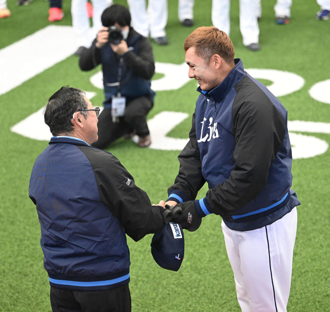 西武対中日　訓示を終えた株式会社西武ライオンズ取締役オーナーの後藤氏（左）は栗山と握手を交わす（撮影・滝沢徹郎）