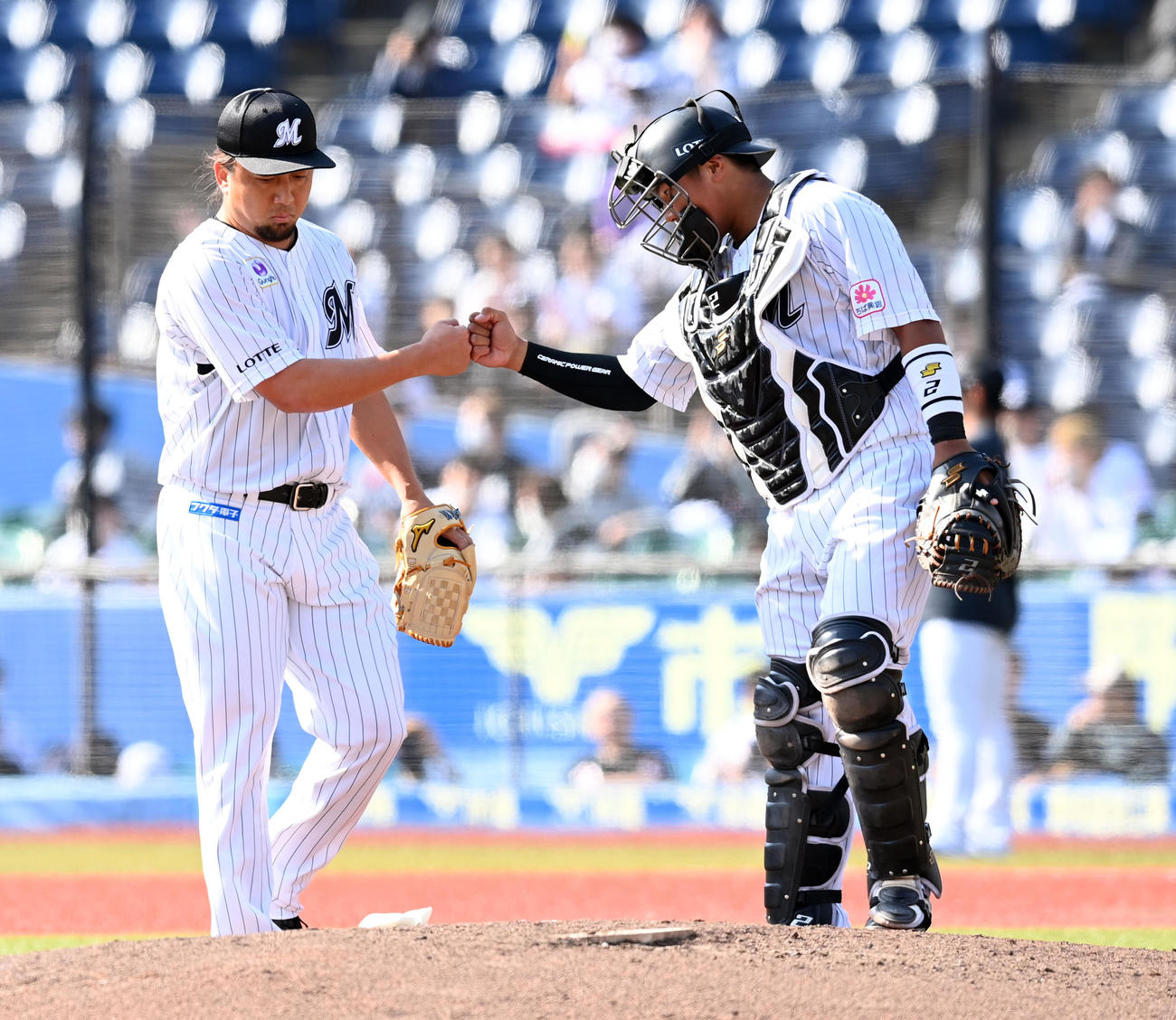 ロッテ対日本ハム　5回からマウンドに上がったロッテ沢村は、捕手の松川とグータッチを交わす（撮影・たえ見朱実）