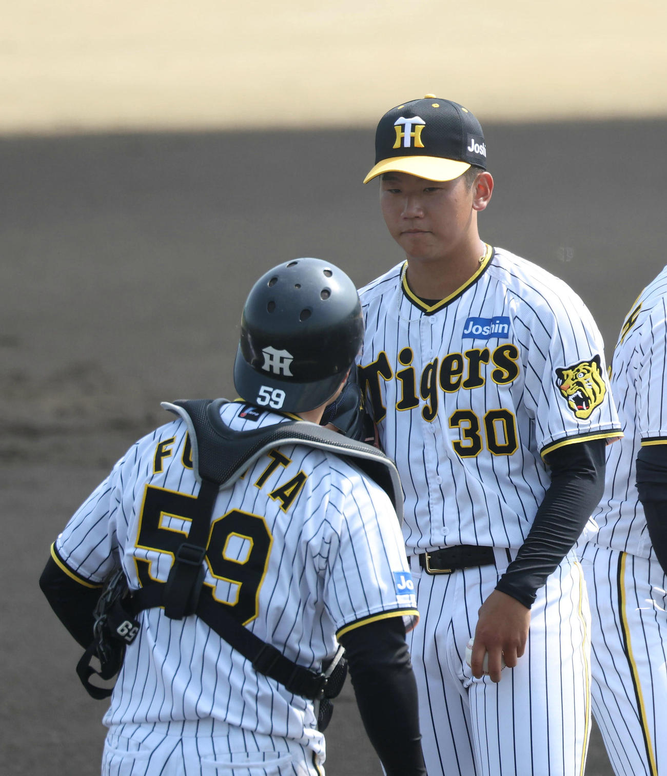 練習試合阪神対立命大　1回表立命大1死一塁、立命大田中陸に中前適時打を打たれマウンドで藤田（左）と話す門別（撮影・白石智彦）