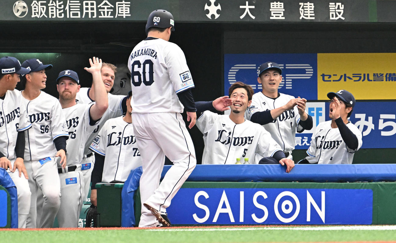 西武対中日　2回裏西武無死一塁、鈴木の適時二塁打から生還した中村（手前）を笑顔で迎える外崎（後方右から3人目）らチームメート（撮影・滝沢徹郎）